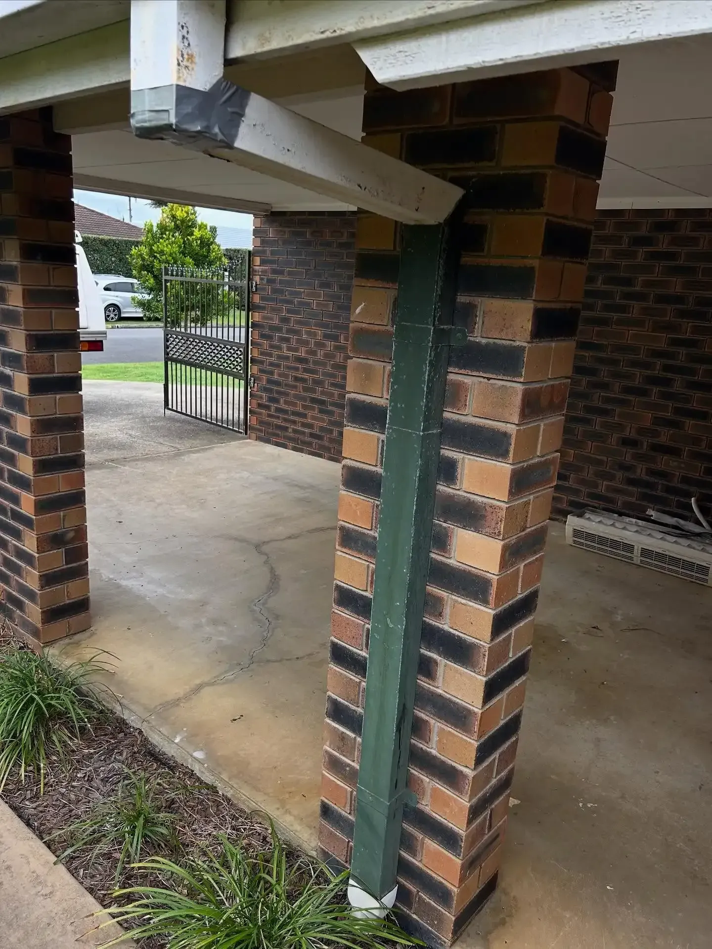 Brick pillar supporting a carport roof; green painted structural beam attached to the pillar. — Vantage Plumbing and Drainage In Pacific Pines, QLD