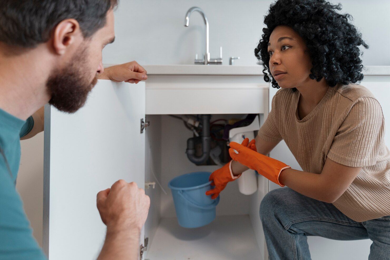 Woman With Gloves and Man Look at Sink Plumbing — Vantage Plumbing and Drainage In Pacific Pines, QLD