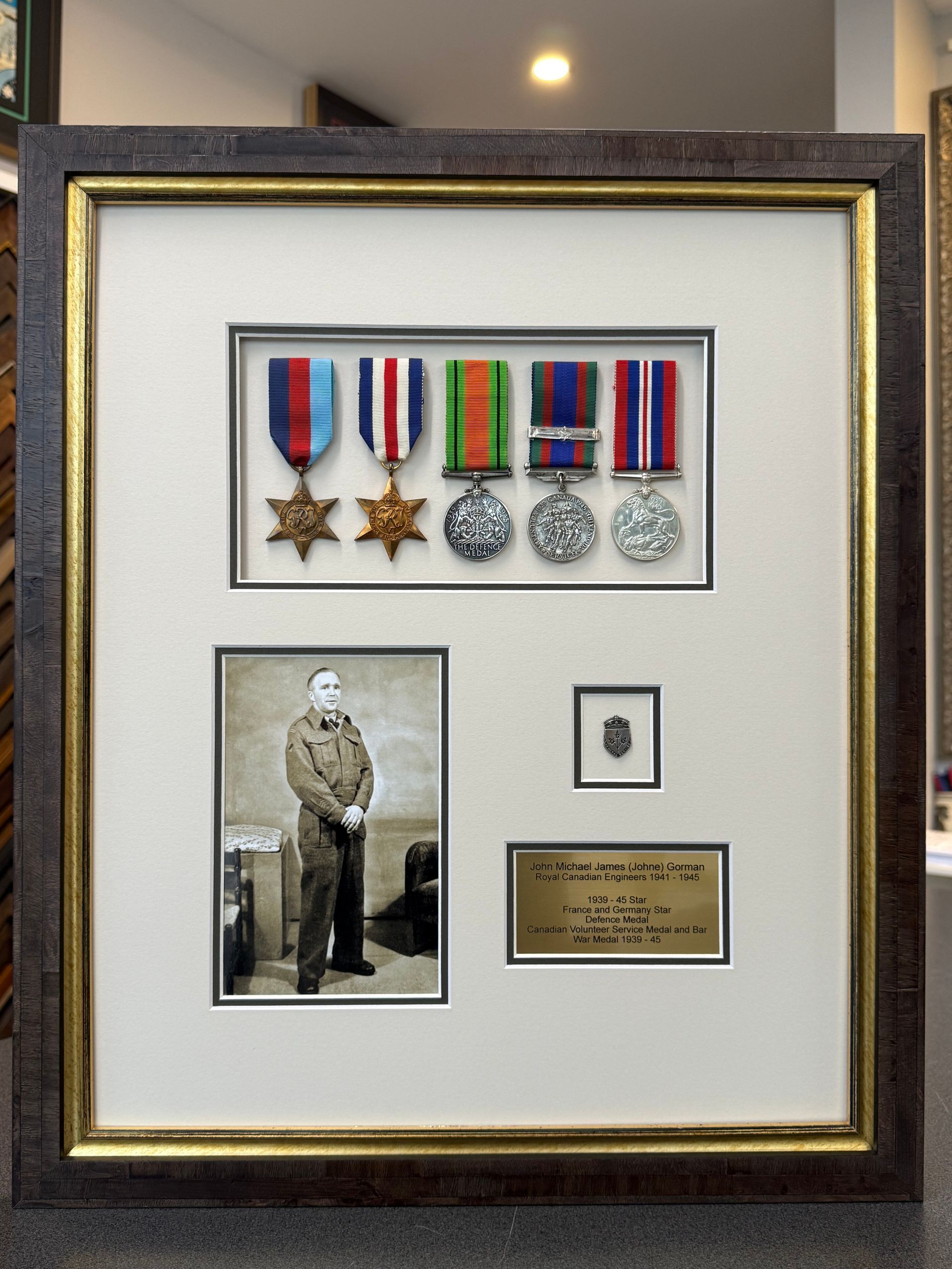 Framed display: war medals, black and white photo of a soldier, small crest, and a plaque with handwritten text. — Framing Alternative in Erina Heights, NSW