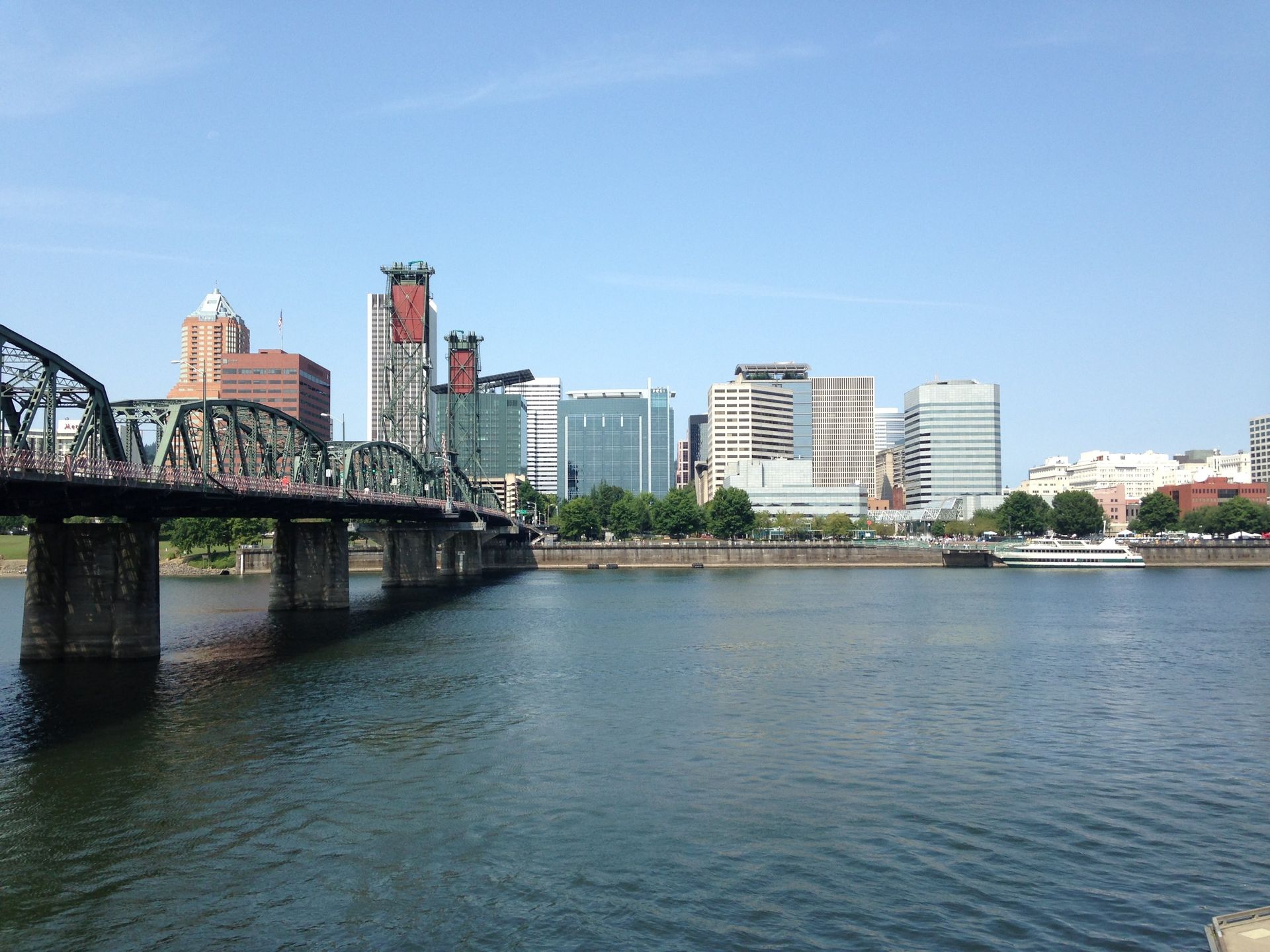 A bridge over a body of water with a city skyline in the background
