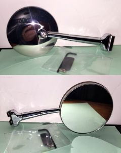 Two chrome side mirrors with circular reflective surfaces, resting on a dark green surface.