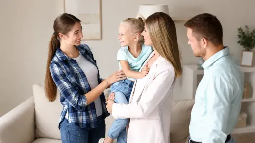 Nanny helping a family at a kitchen table