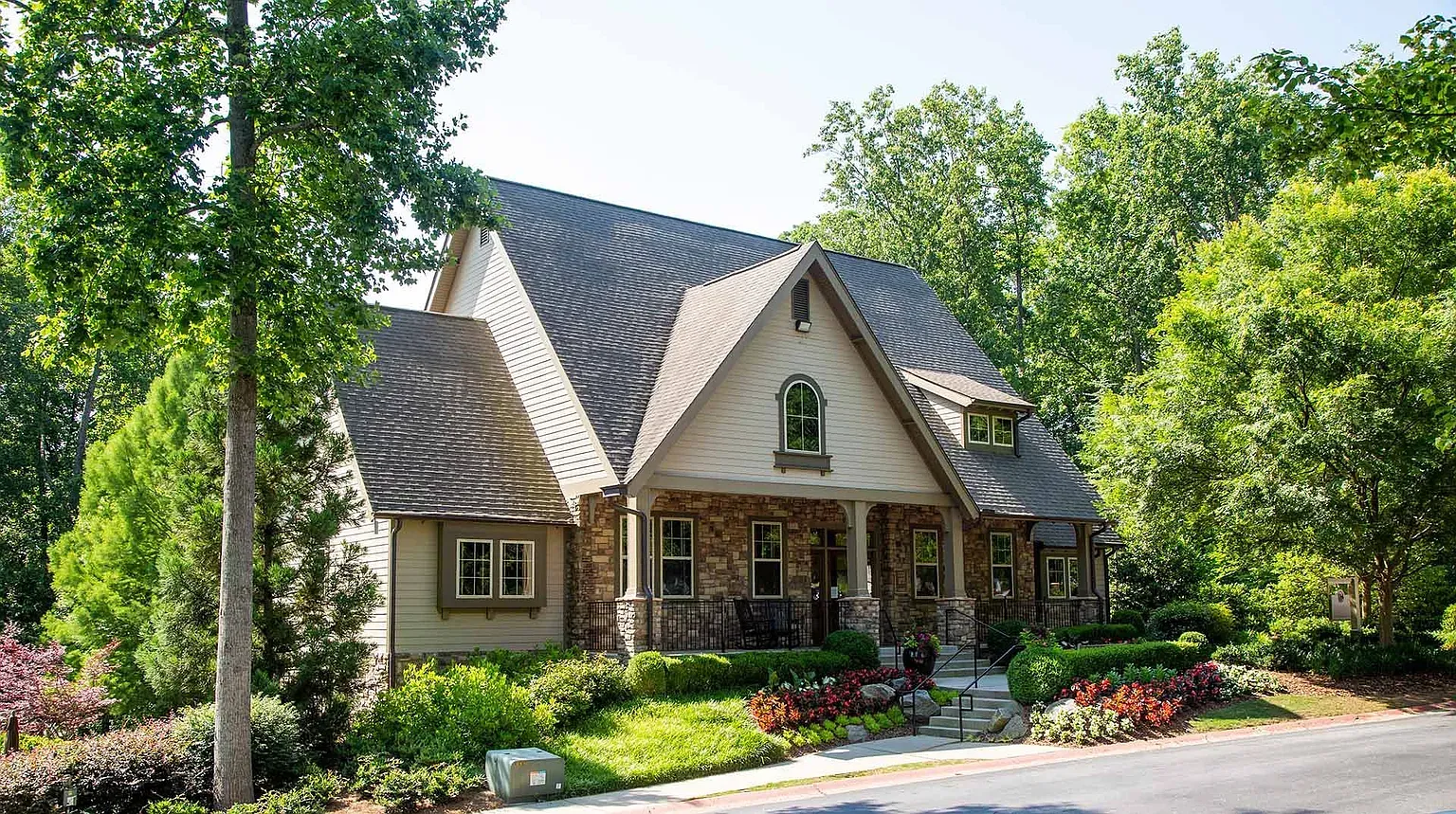 A living room with a couch, two coffee tables, wall art and plants.