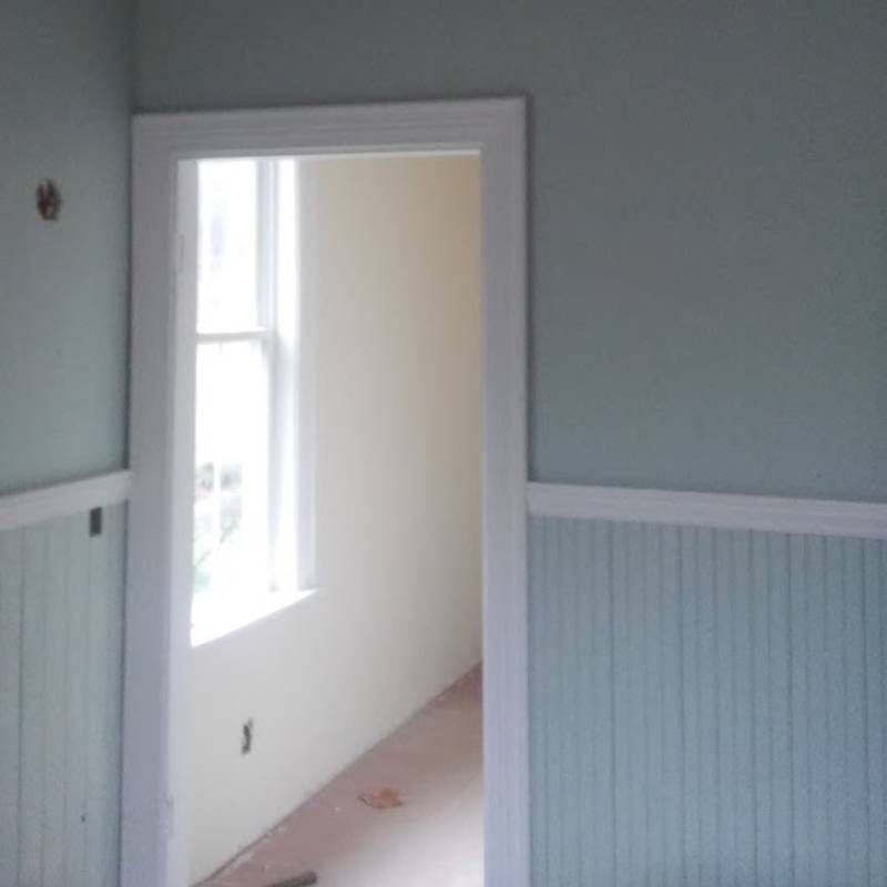 An empty room with light blue walls and a window