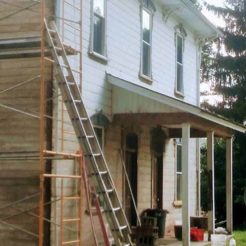 A white house with a ladder on the side of it