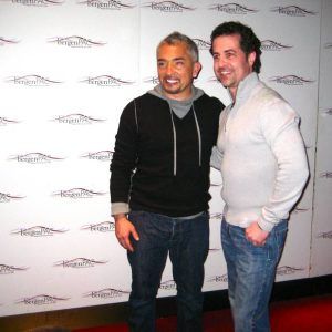 Two men posing together at a step-and-repeat backdrop, smiling at a red carpet event