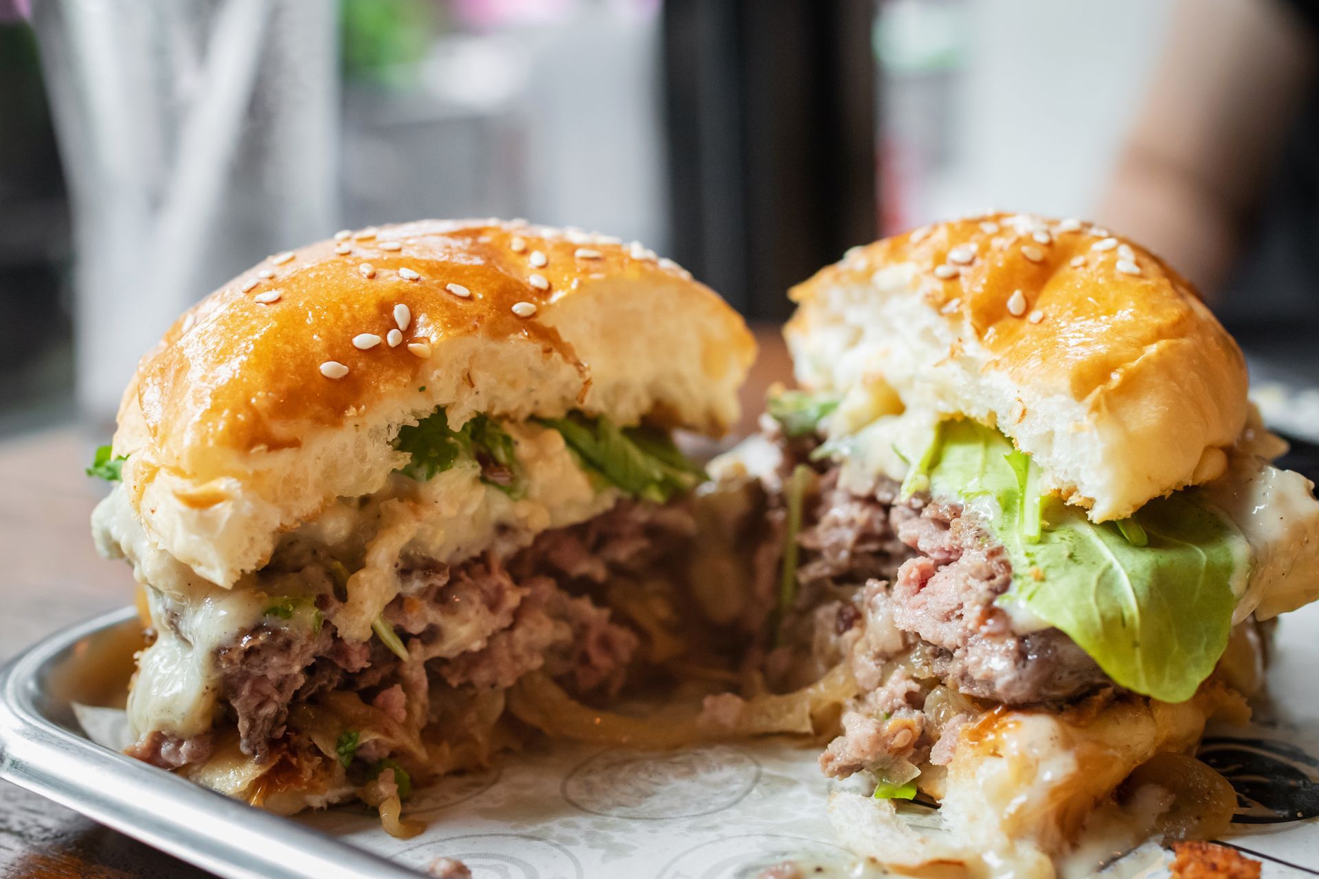 A close up of a hamburger cut in half on a plate.