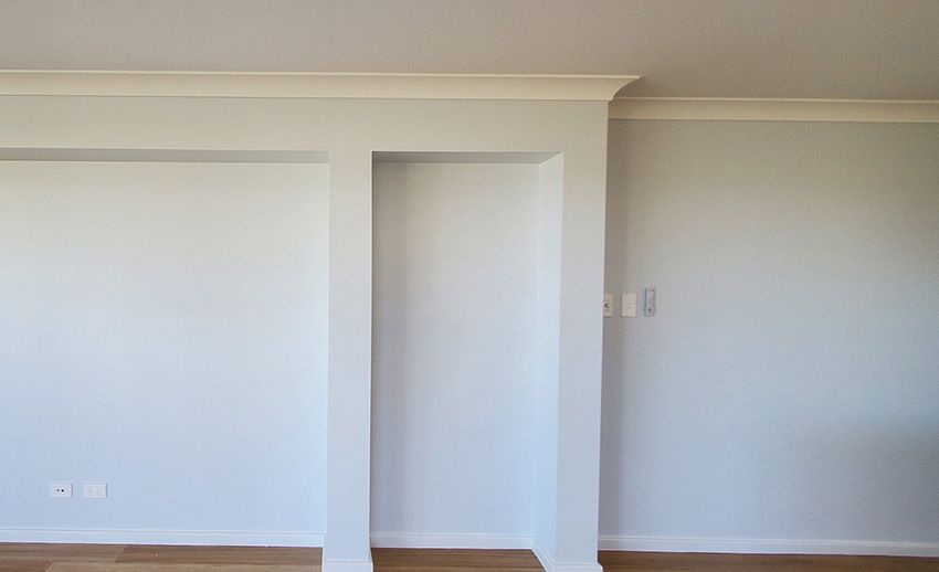 An Empty Room with White Walls and a Wooden Floor — JWP Painting & Property Services in Terrigal, NSW