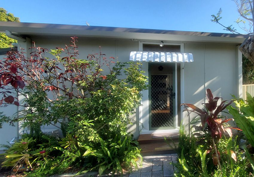 A Small White House Surrounded by Trees and Bushes — JWP Painting & Property Services in Terrigal, NSW