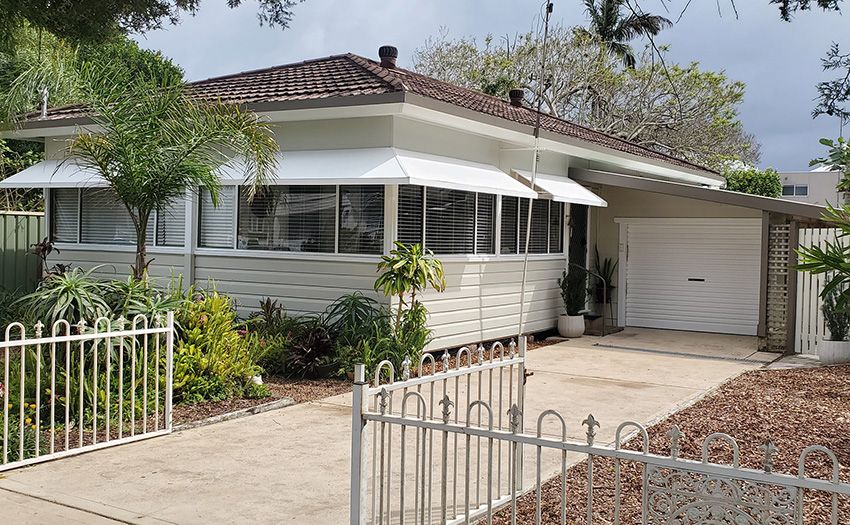 A White House with a Fence Around It and a Garage — JWP Painting & Property Services in Newcastle, NSW