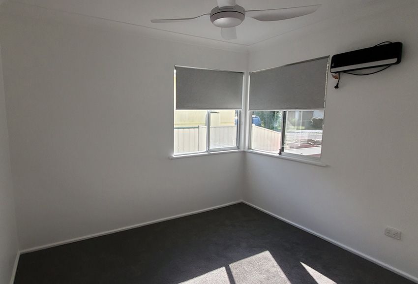 An Empty Room with a Ceiling Fan and Windows — JWP Painting & Property Services in Woy Woy, NSW