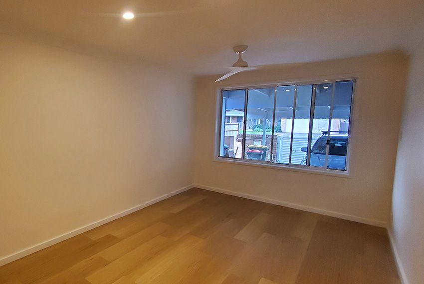 An Empty Room with a Large Window and a Ceiling Fan — JWP Painting & Property Services in Umina Beach, NSW