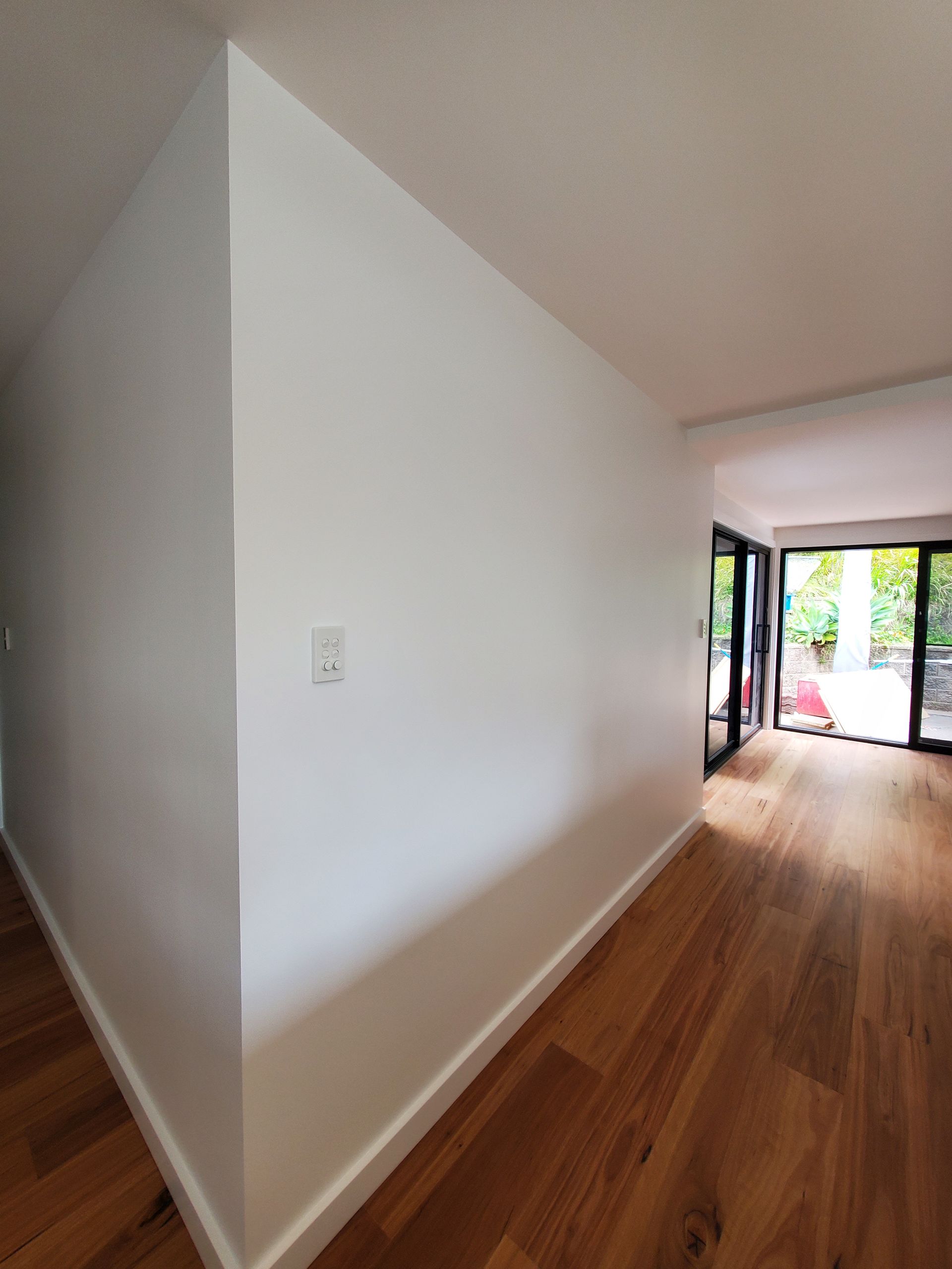 A Hallway With White Walls and Wooden Floors — JWP Painting & Property Services in Ettalong Beach, NSW