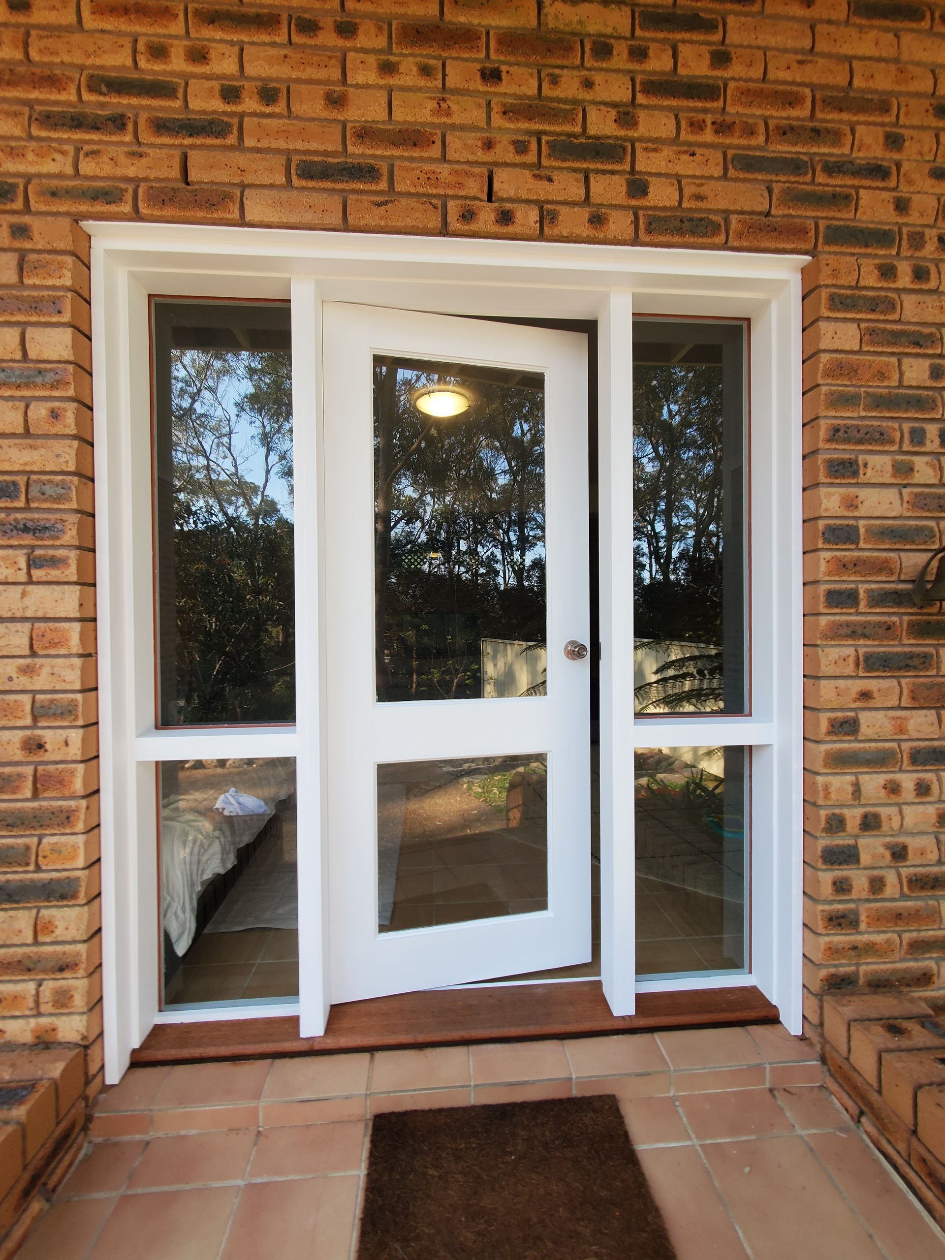 A White Door With a Brick Wall Behind It — JWP Painting & Property Services in Ettalong Beach, NSW