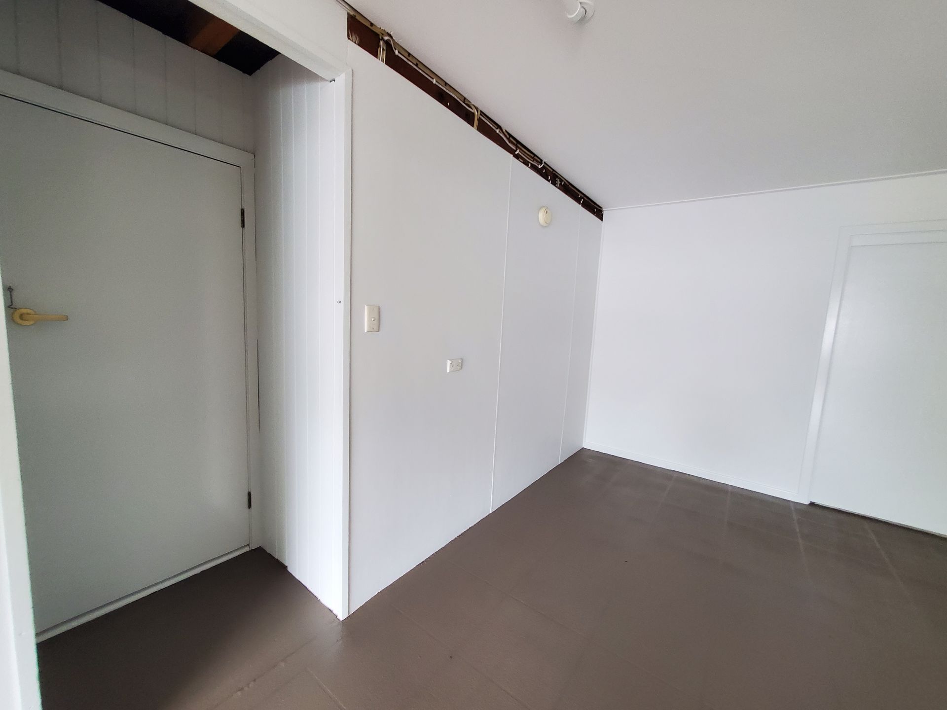 An Empty Room With White Walls and a Door — JWP Painting & Property Services in Ettalong Beach, NSW