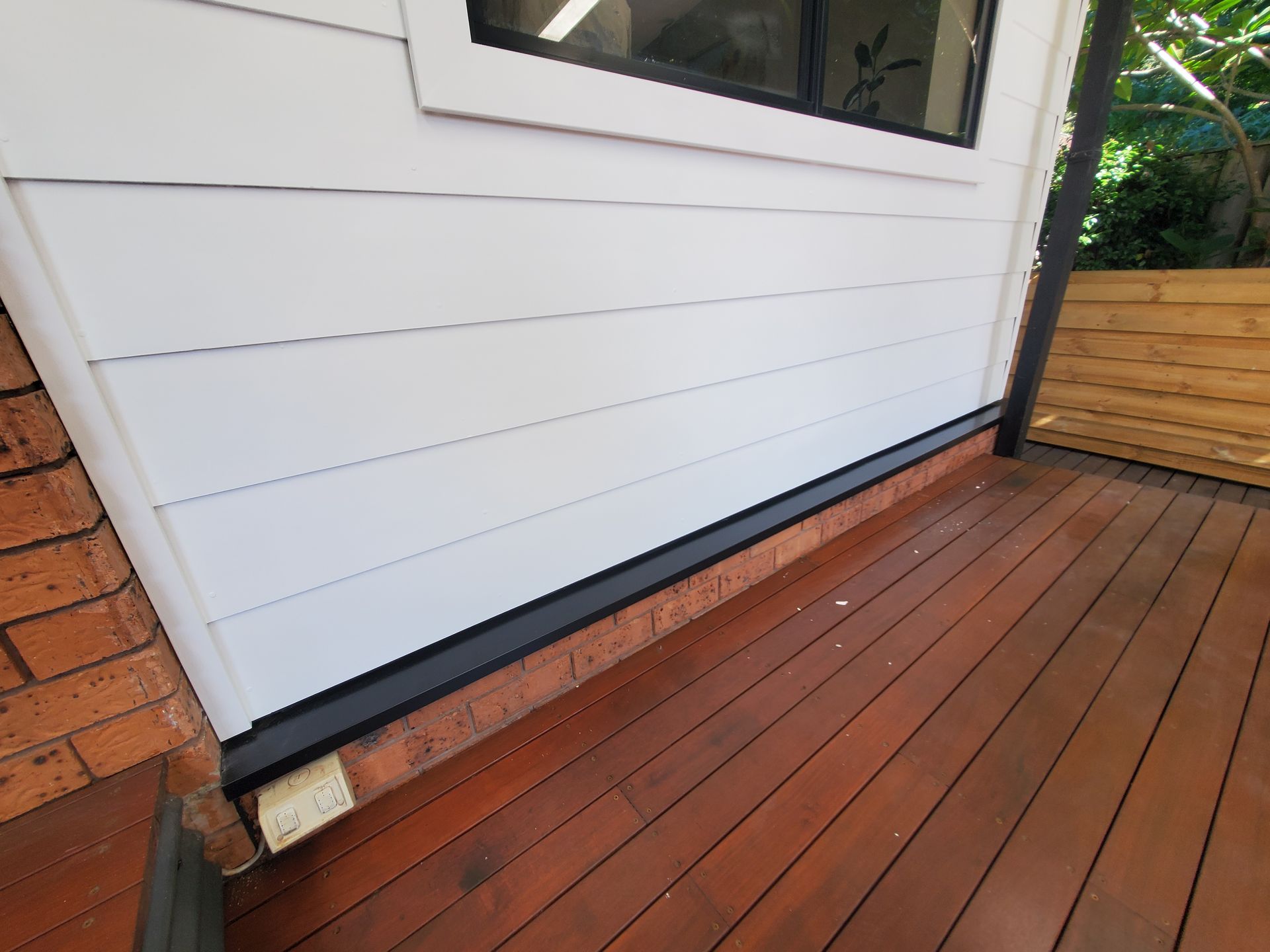 A White House With a Wooden Deck in Front of It — JWP Painting & Property Services in Ettalong Beach, NSW