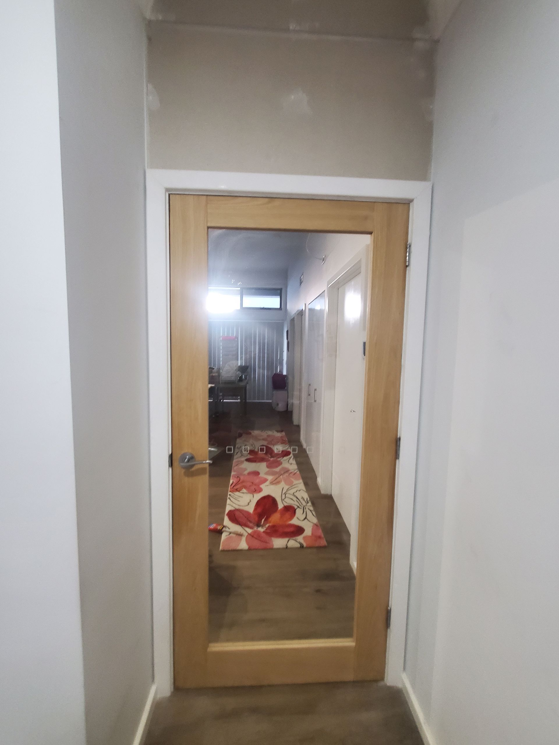 A Hallway With a Mirrored Door and a Rug on the Floor — JWP Painting & Property Services in Ettalong Beach, NSW