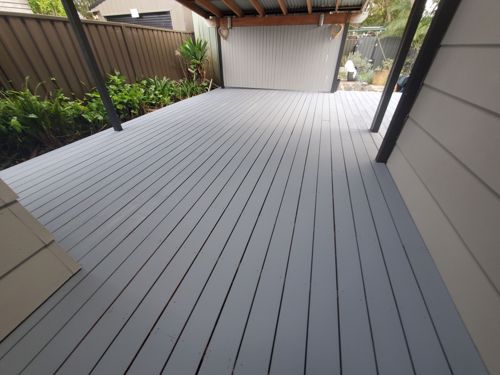 A Grey Deck With a Fence in the Background — JWP Painting & Property Services in Ettalong Beach, NSW