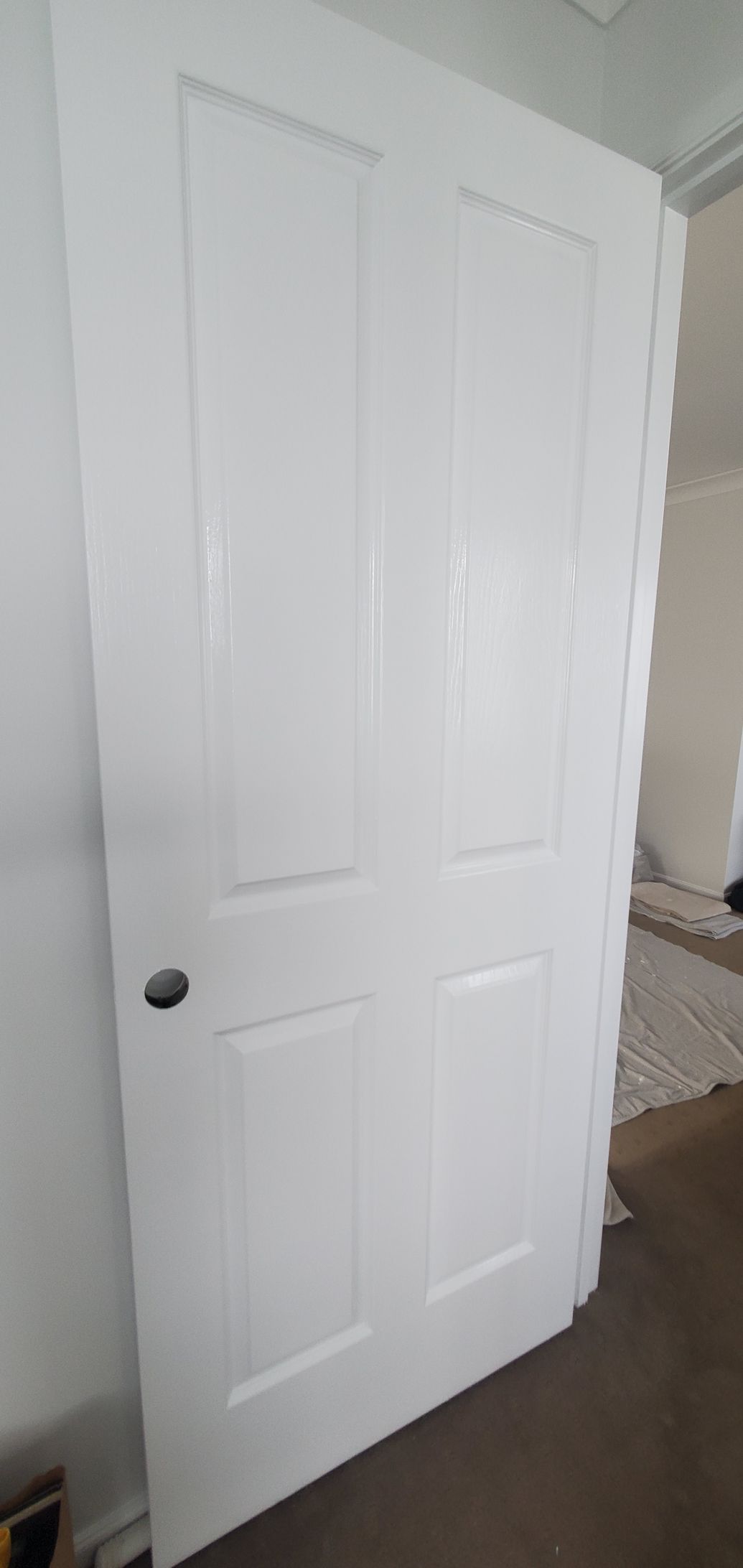 A White Door is Sitting in a Room Next to a Wall — JWP Painting & Property Services in Ettalong Beach, NSW