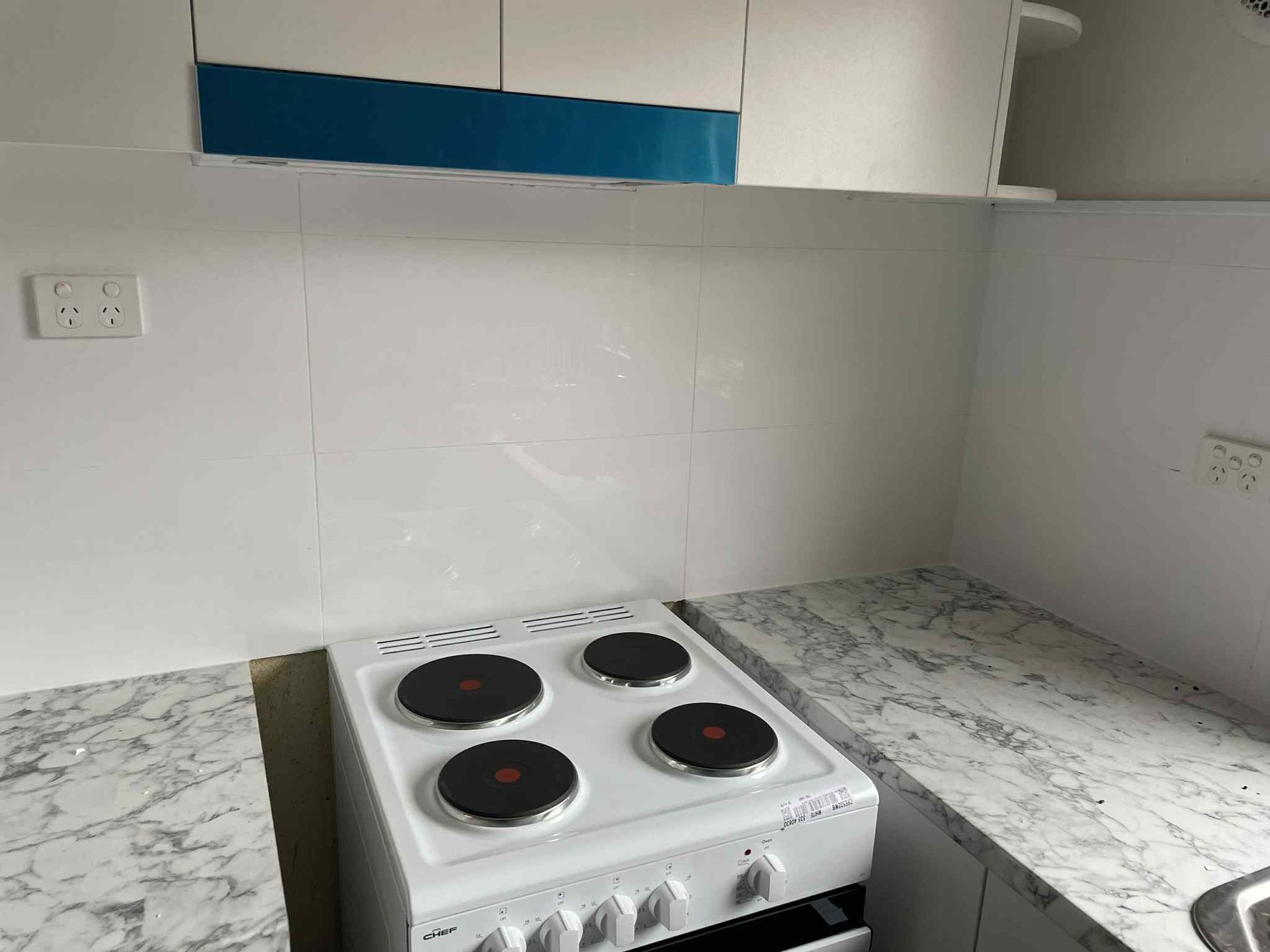 Electric freestanding cooktop installation with dedicated power outlet in a modern Hampton kitchen