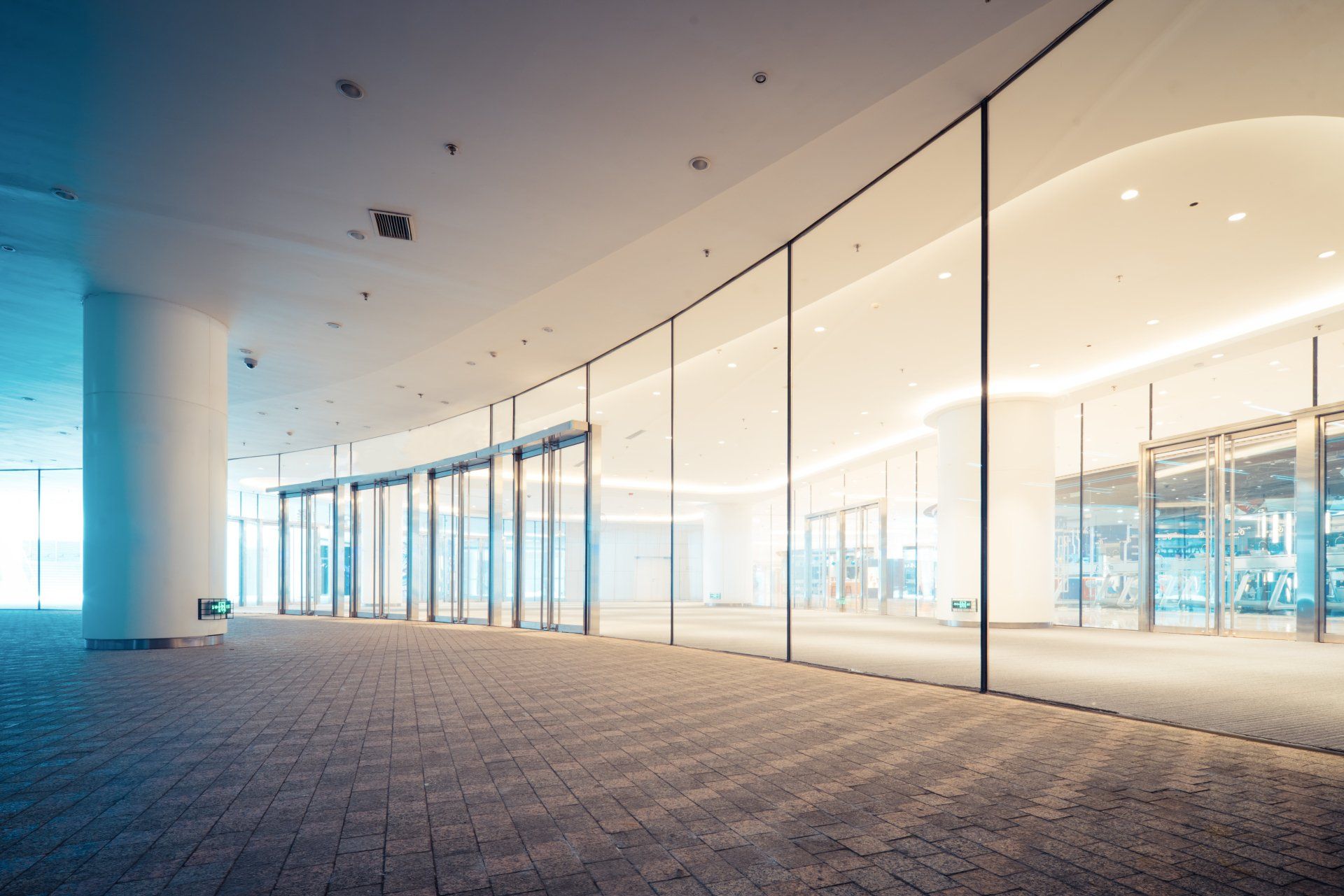 A large empty building with a lot of windows and a carpeted floor.
