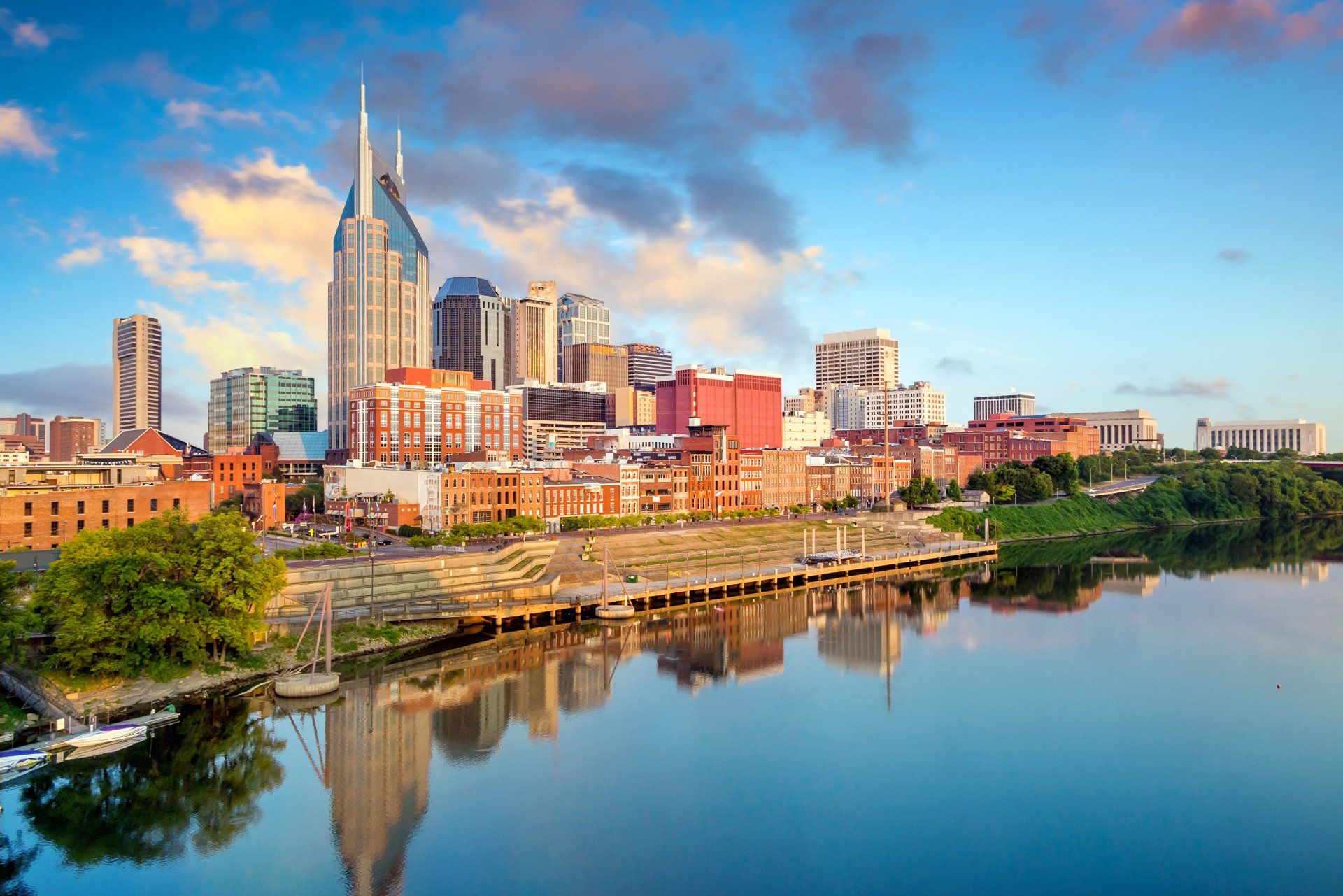 The city skyline of nashville is reflected in the water.