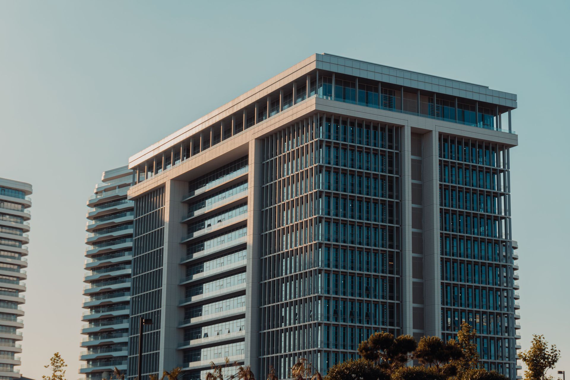 Modern high-rise office building with glass facade at sunset