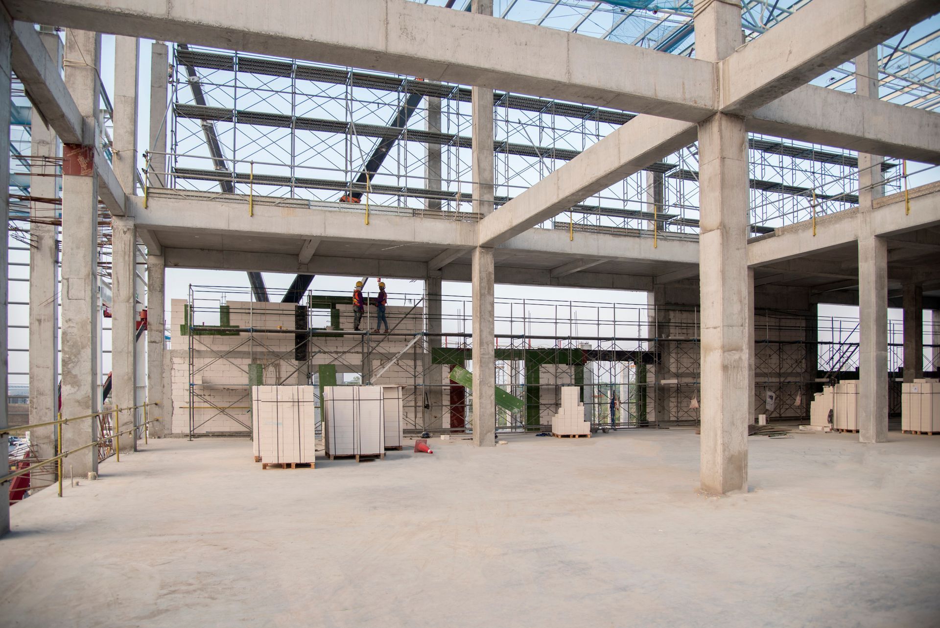 Construction site interior, concrete pillars and beams, unfinished building, materials visible. Construction site interior, concrete pillars and beams, unfinished building, materials visible.