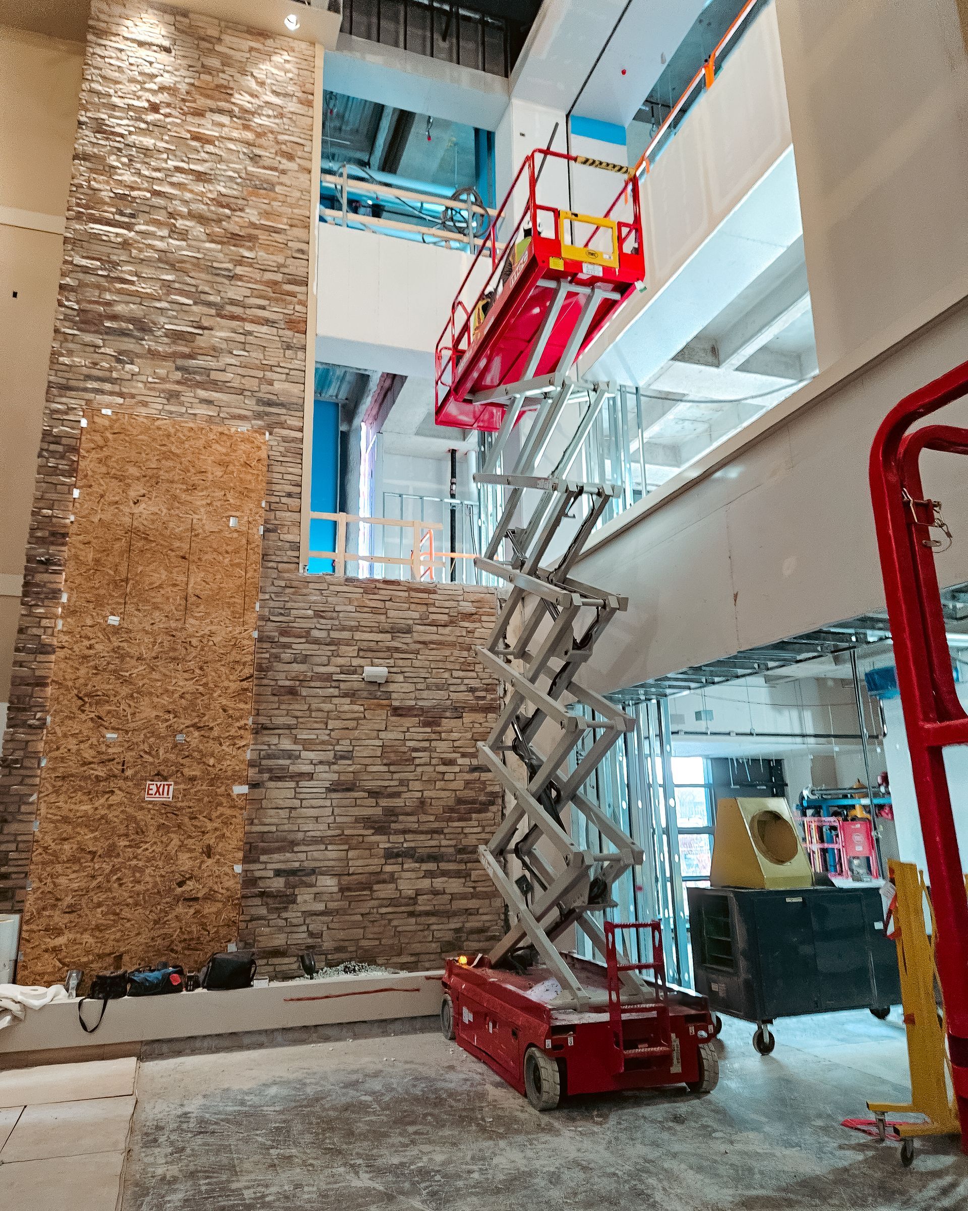 A scissor lift is being used in a building under construction.