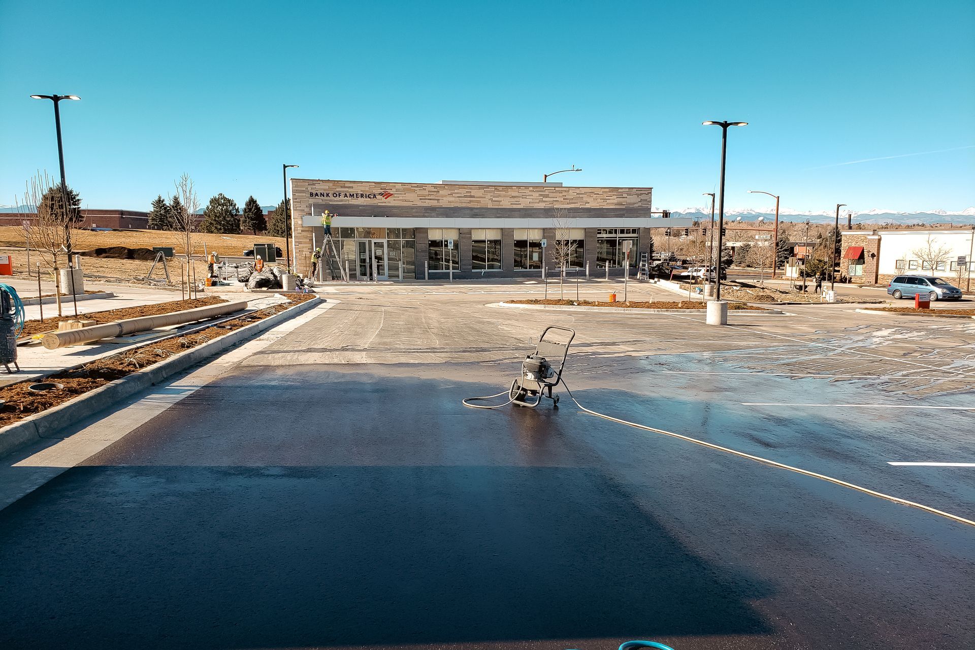 A car is driving down a road in front of a building.