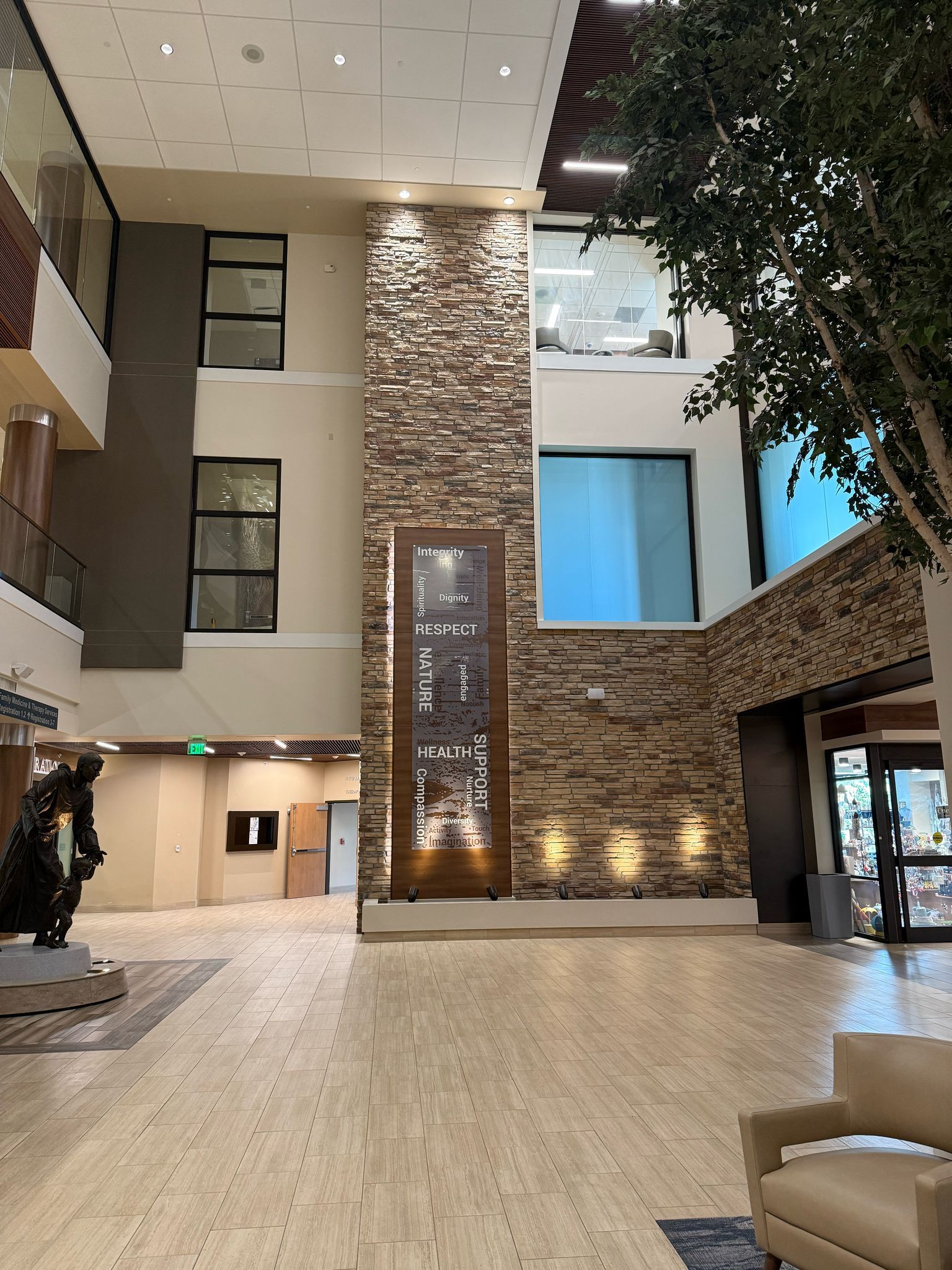 Lobby with stone accent wall, windows, and decorative art. Interior view with neutral colors and modern design.