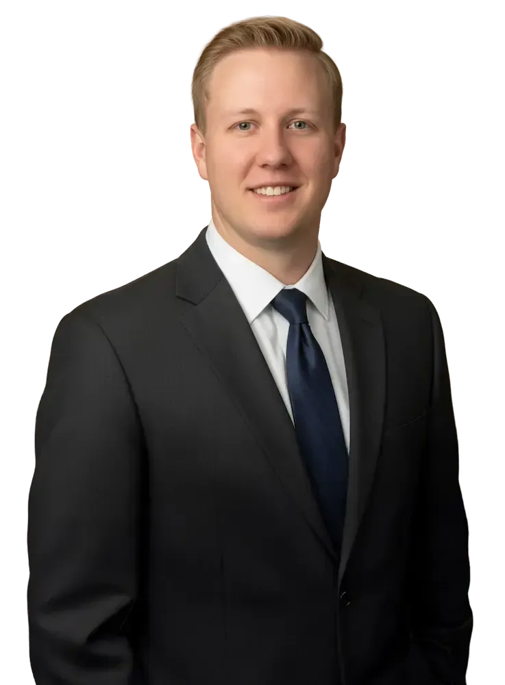 Jay Tobey in a suit smiling, looking at the viewer. He is against a tansparent background.