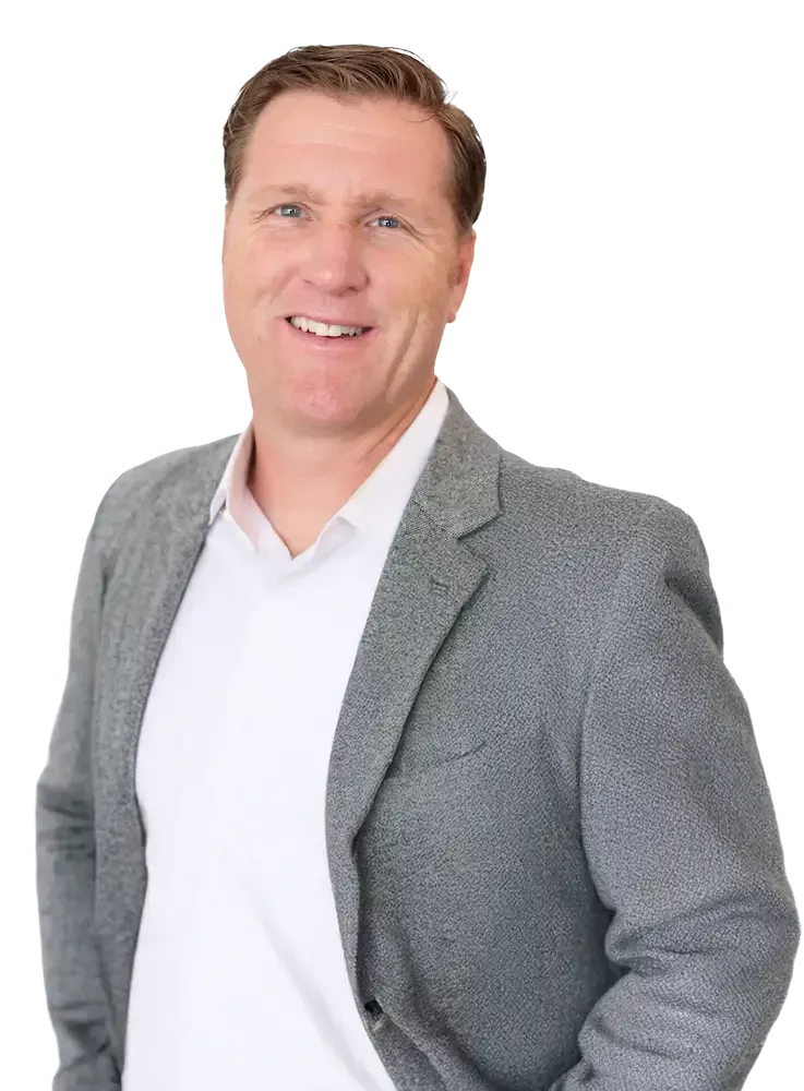 Scott Stratton in a suit smiling, looking at the viewer. He is against a tansparent background.