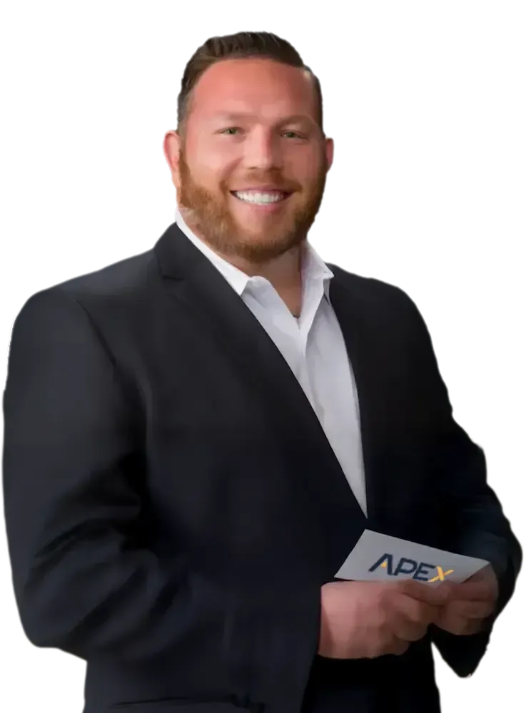 Trent Bright portrait in a suit smiles, looking at the viewer. He has a beard and is against a transparent background.
