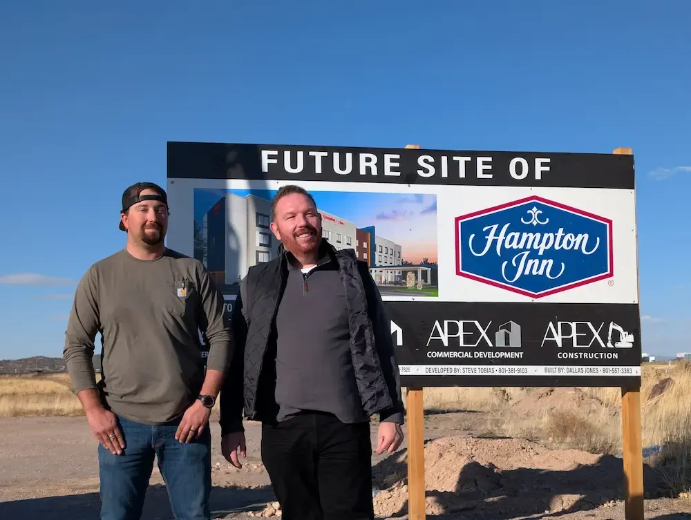 Two men standing next to a 