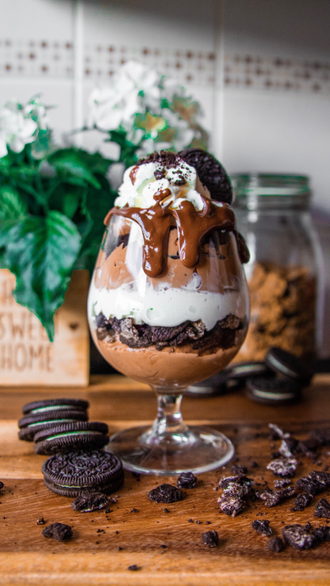 a chocolate ice cream sundae with oreos and whipped cream