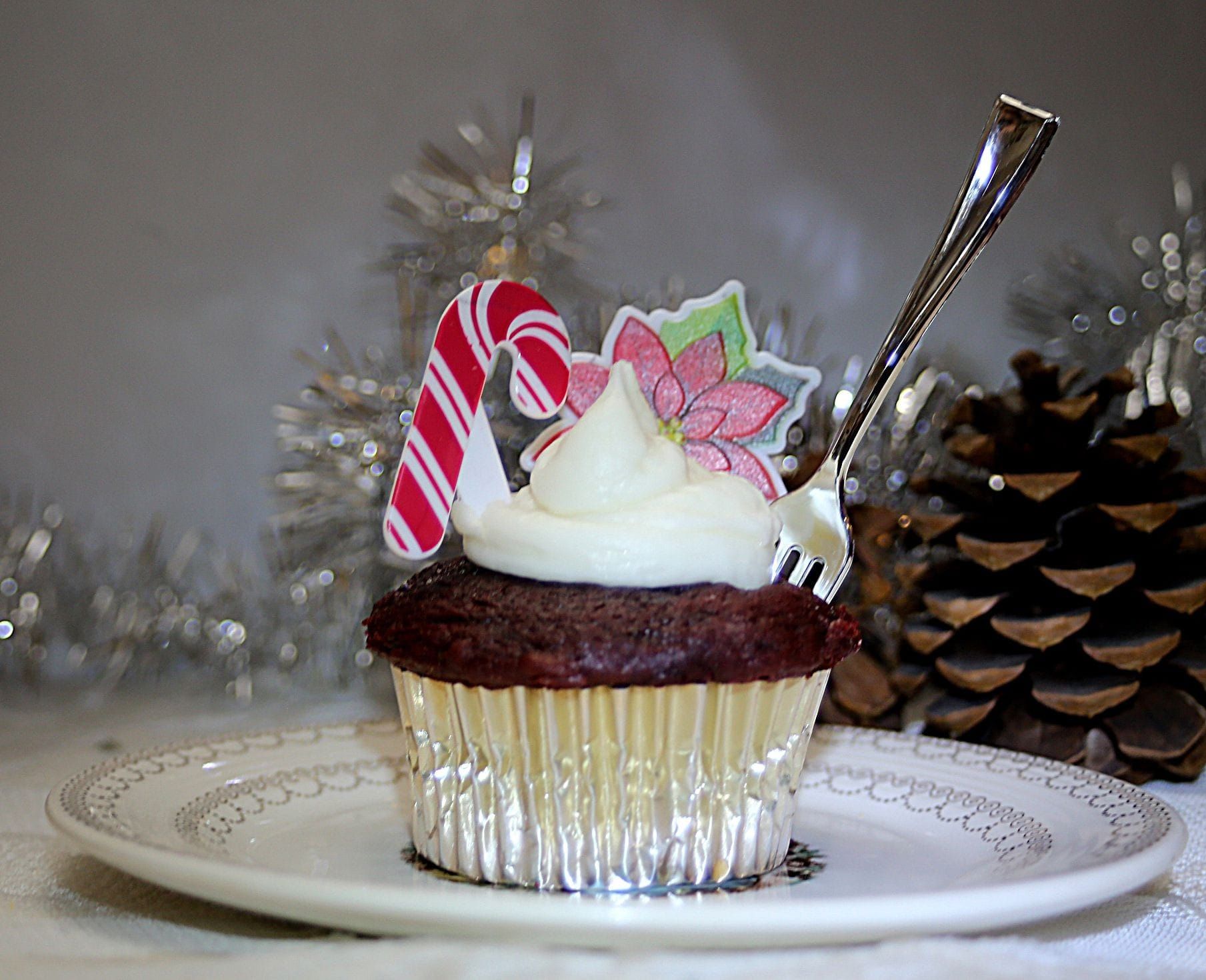 a cupcake with white frosting and a candy cane on top