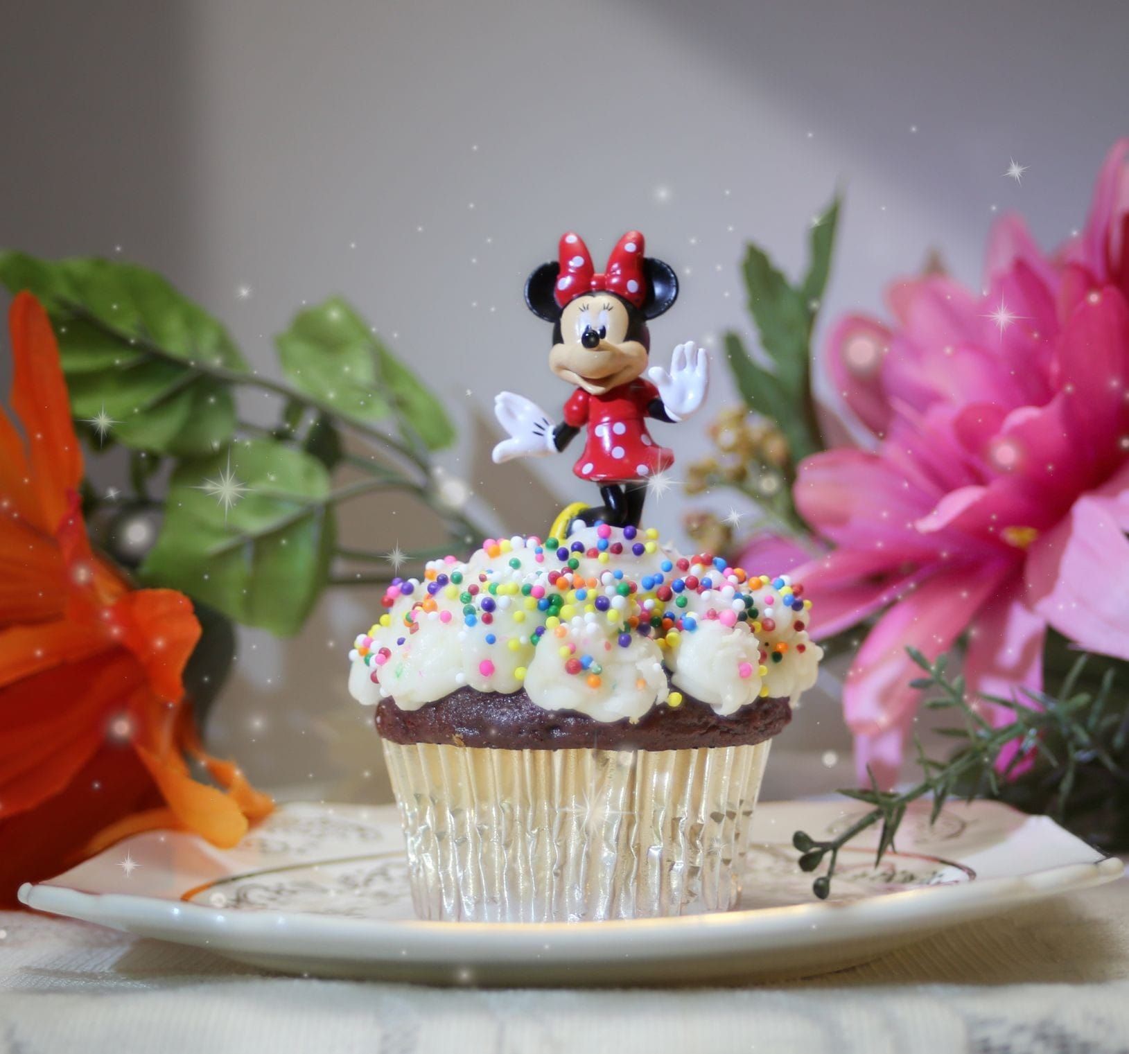 a cupcake with a minnie mouse figurine on top