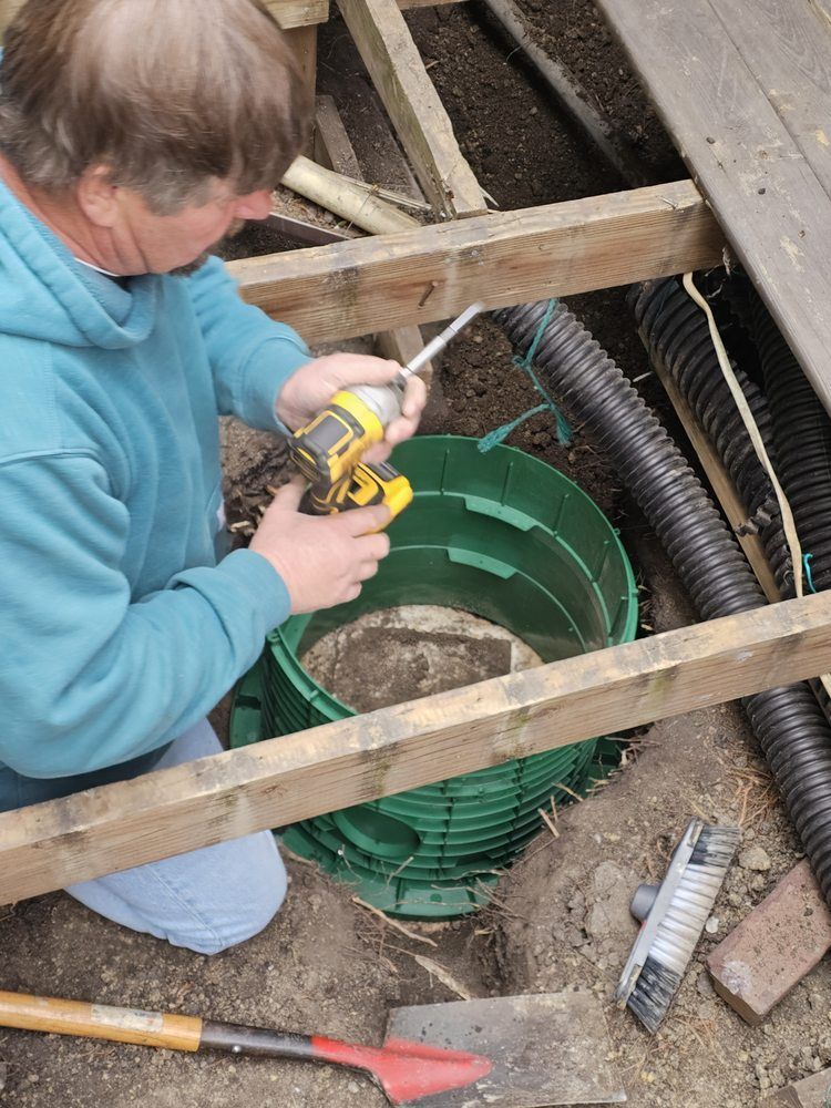 A man is using a drill to fix a hole in the ground