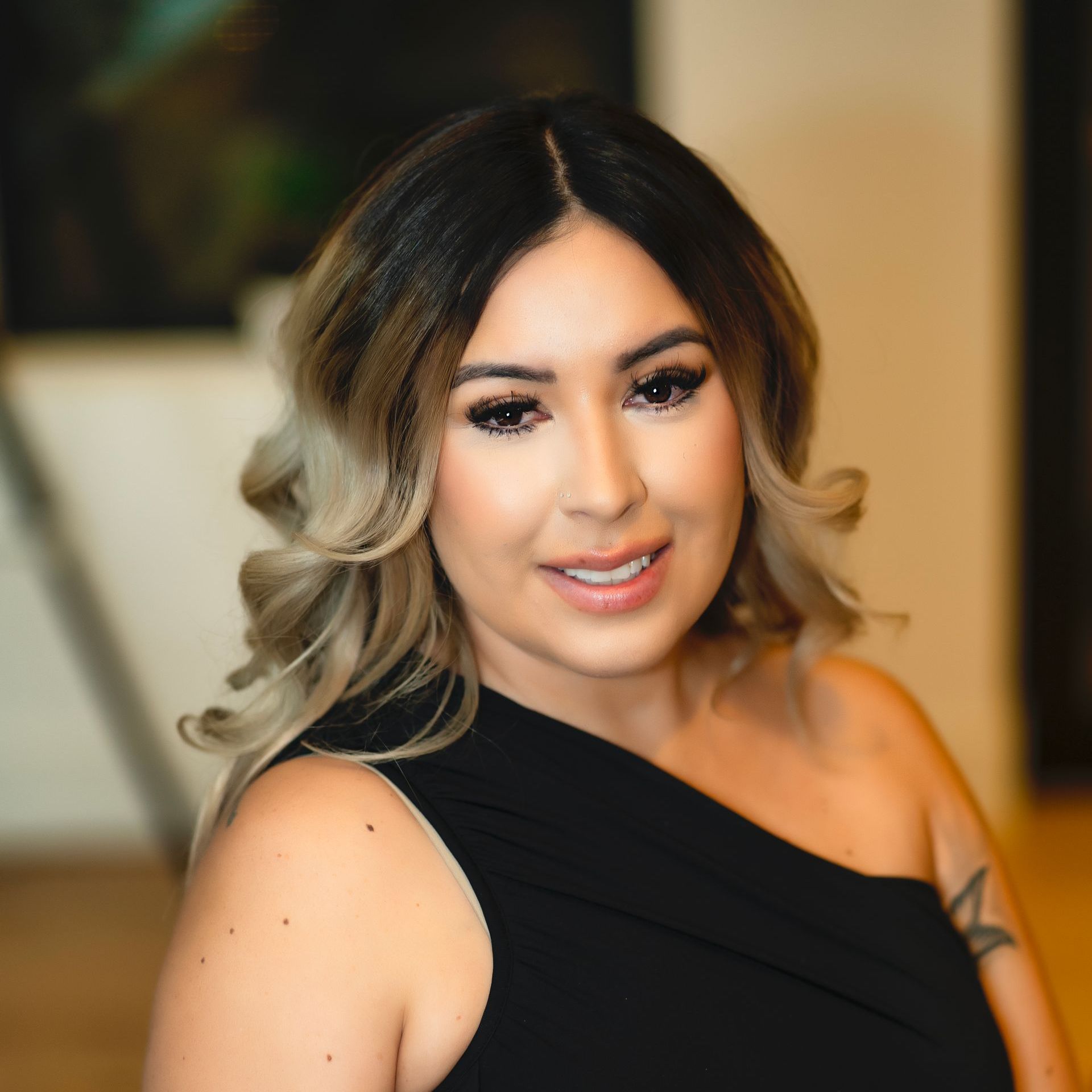 A woman in a black dress is smiling for the camera.
