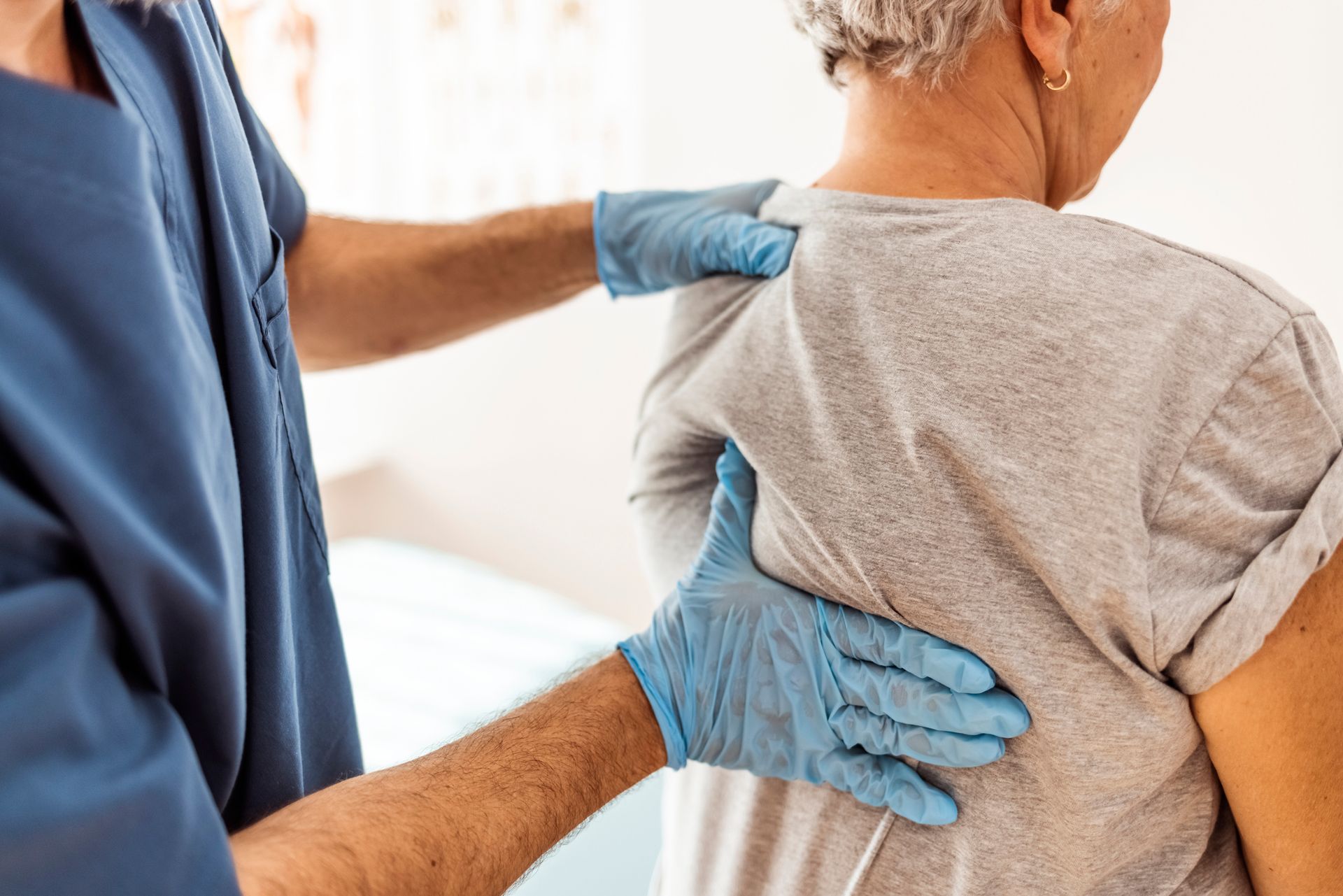 A doctor is examining the back of a patient.