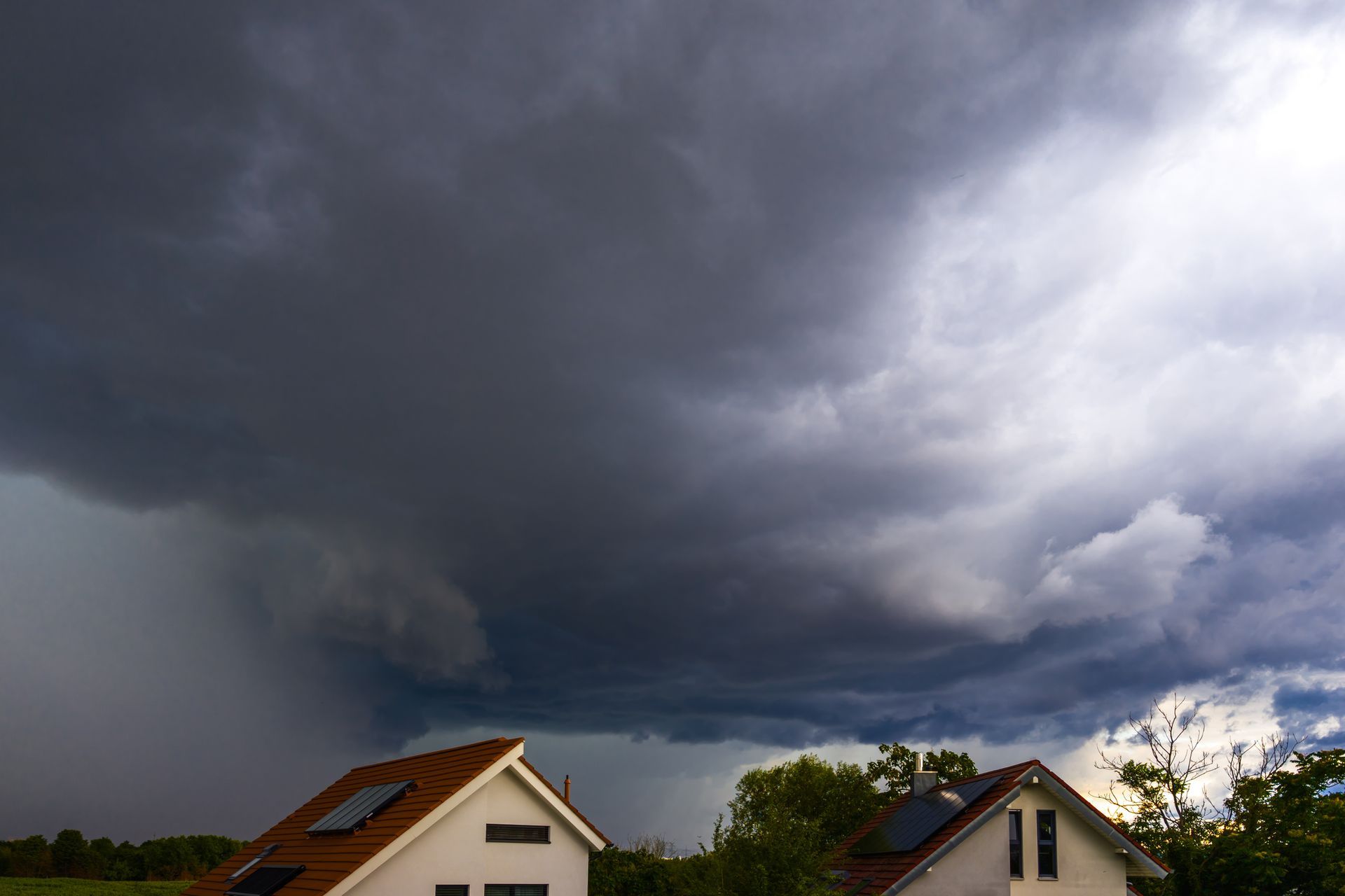 Dark summer thunderstorm approaching an Illinois neighborhood with whole-home surge protection.