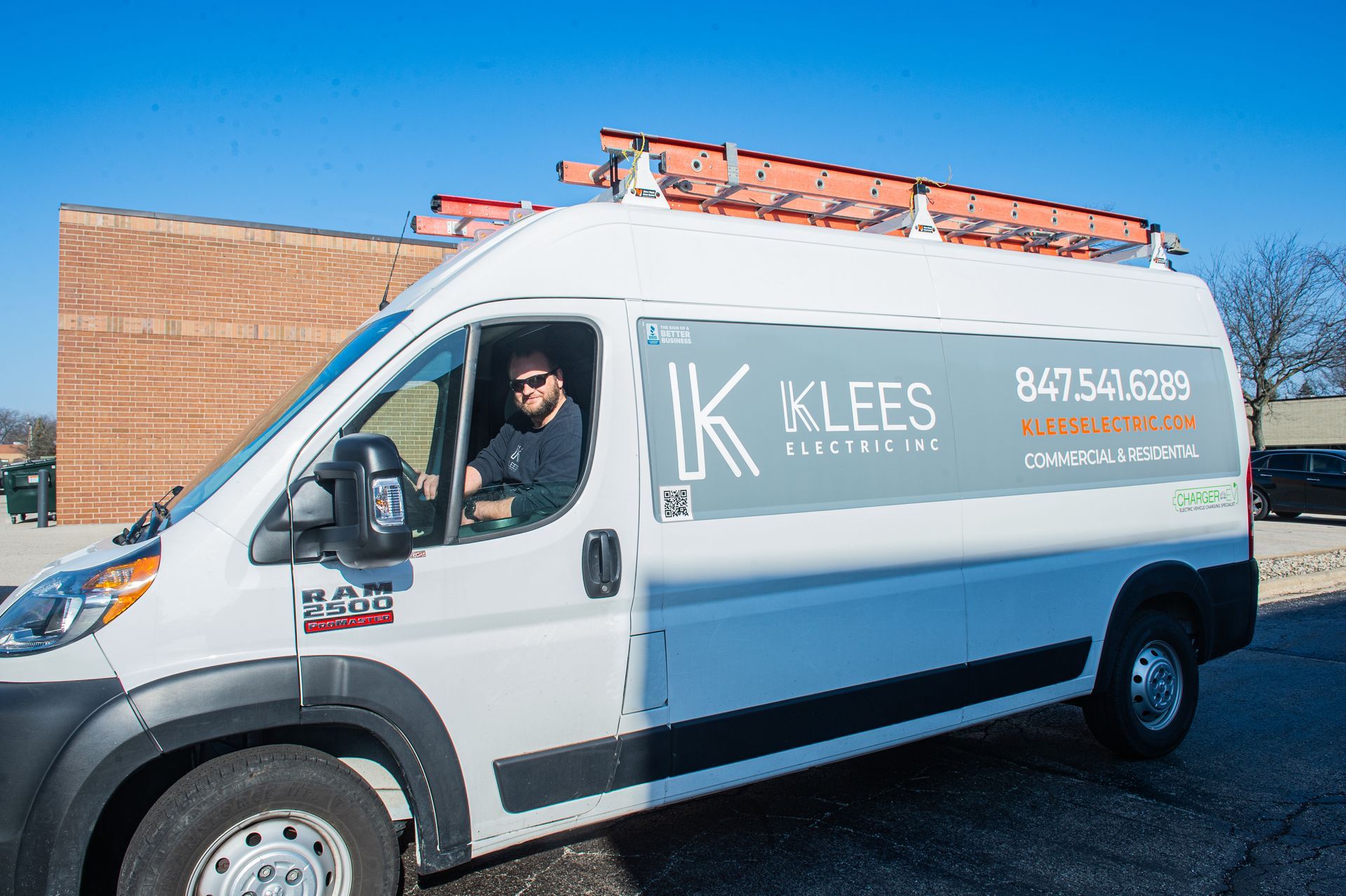 A white van is parked in front of a building.