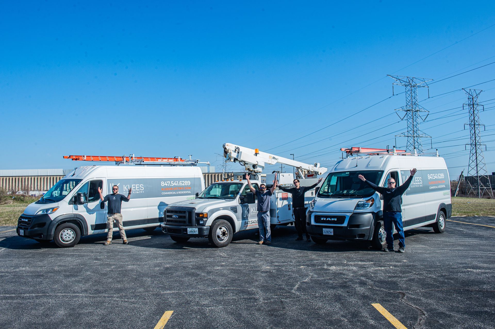 A Klees electric inc truck with a crane attached to it is parked in a parking lot.