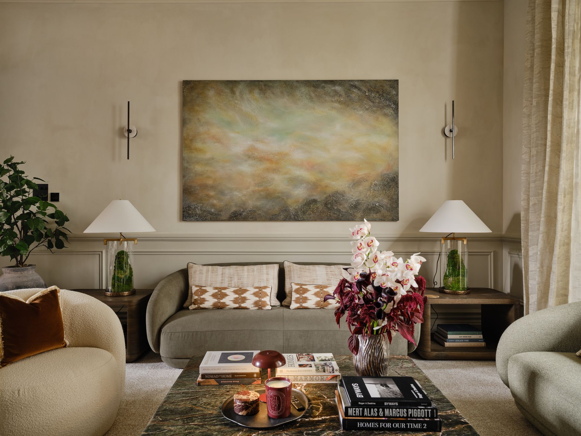 Elegant living room with neutral sofas, lamps, and a large abstract painting above the couch