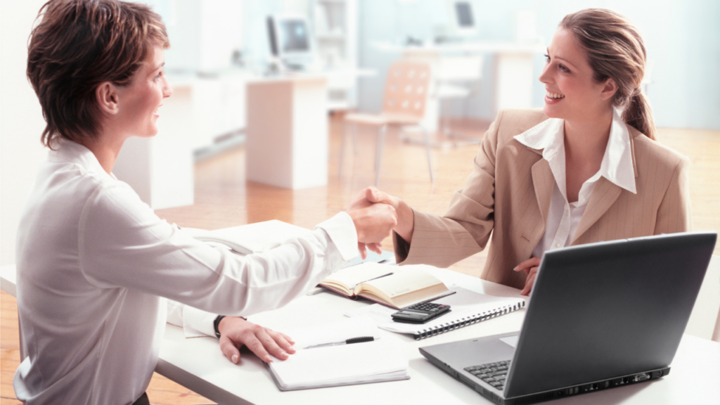 Two Professionals in an Office Handshake — Michelle Crutcher Business Coaching & Consulting in The Entrance North, NSW
