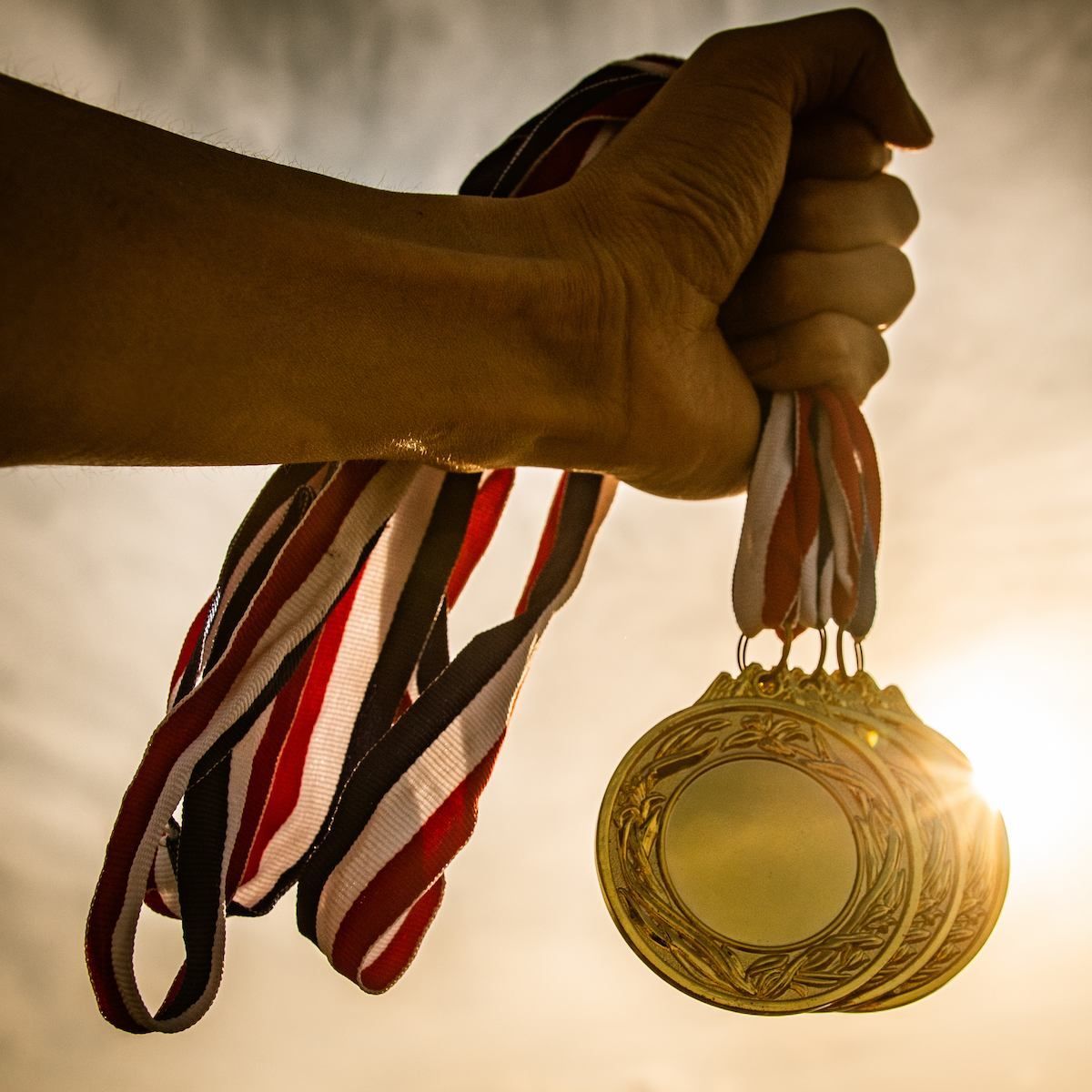 A Hand Holds Several Gold Medals — Michelle Crutcher Business Coaching & Consulting in The Entrance North, NSW