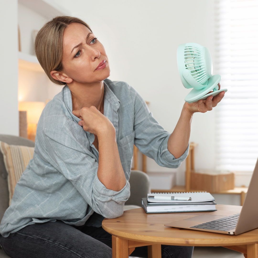 Woman Holding A Small Fan, Looking Thoughtful — Michelle Crutcher Business Coaching & Consulting in The Entrance North, NSW