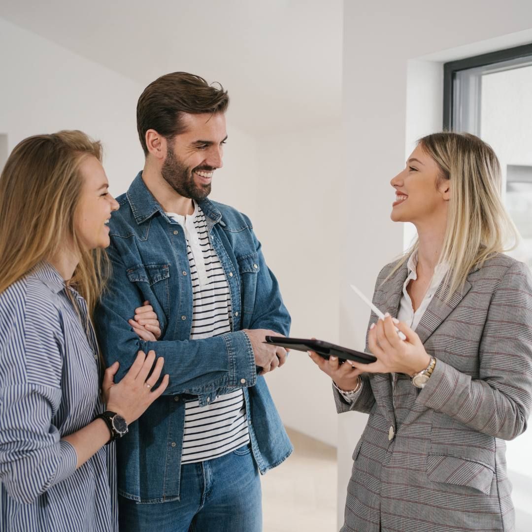 A Couple Smiles While Talking To Estate Agent — Michelle Crutcher Business Coaching & Consulting in The Entrance North, NSW
