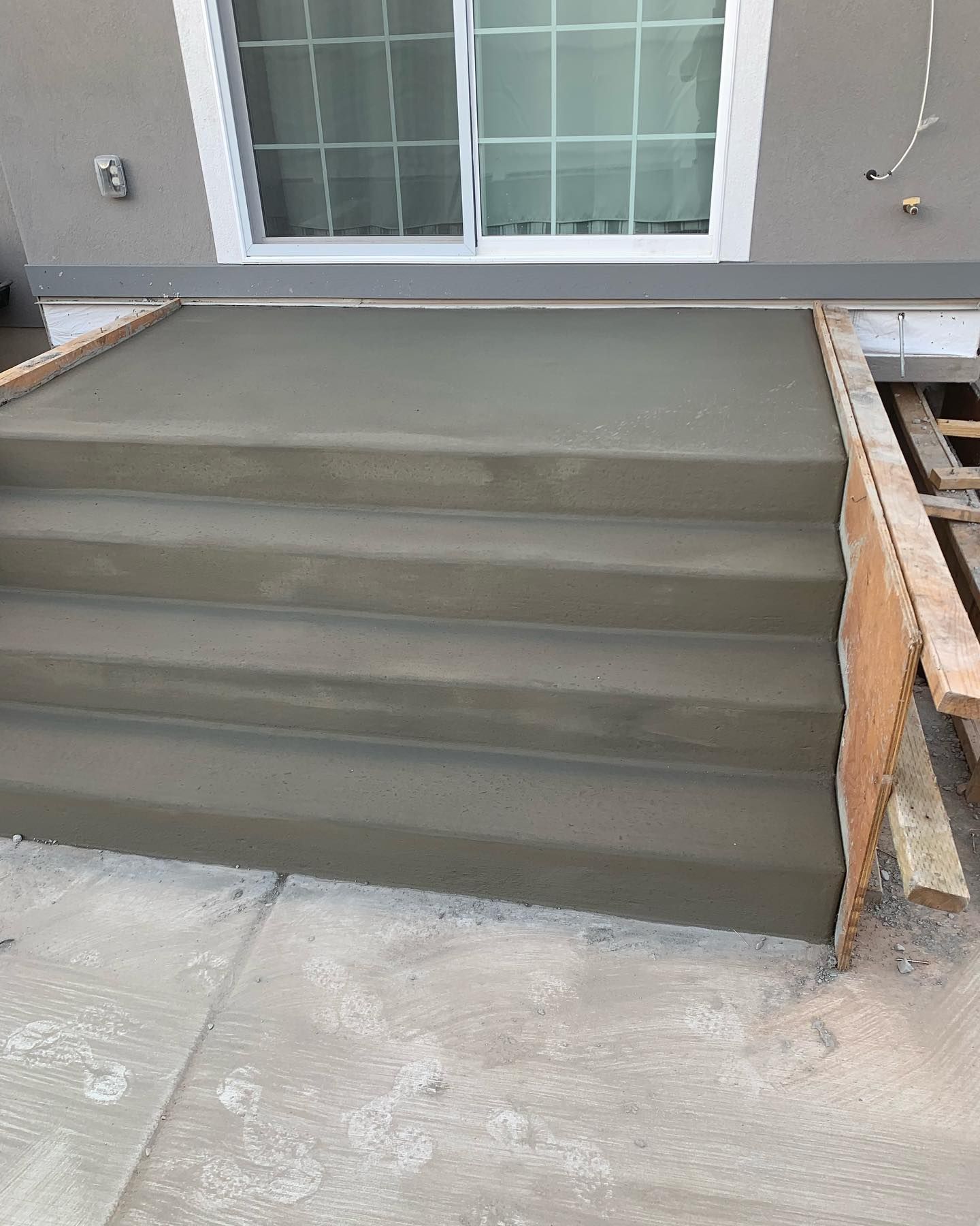 A concrete staircase is being built in front of a house.